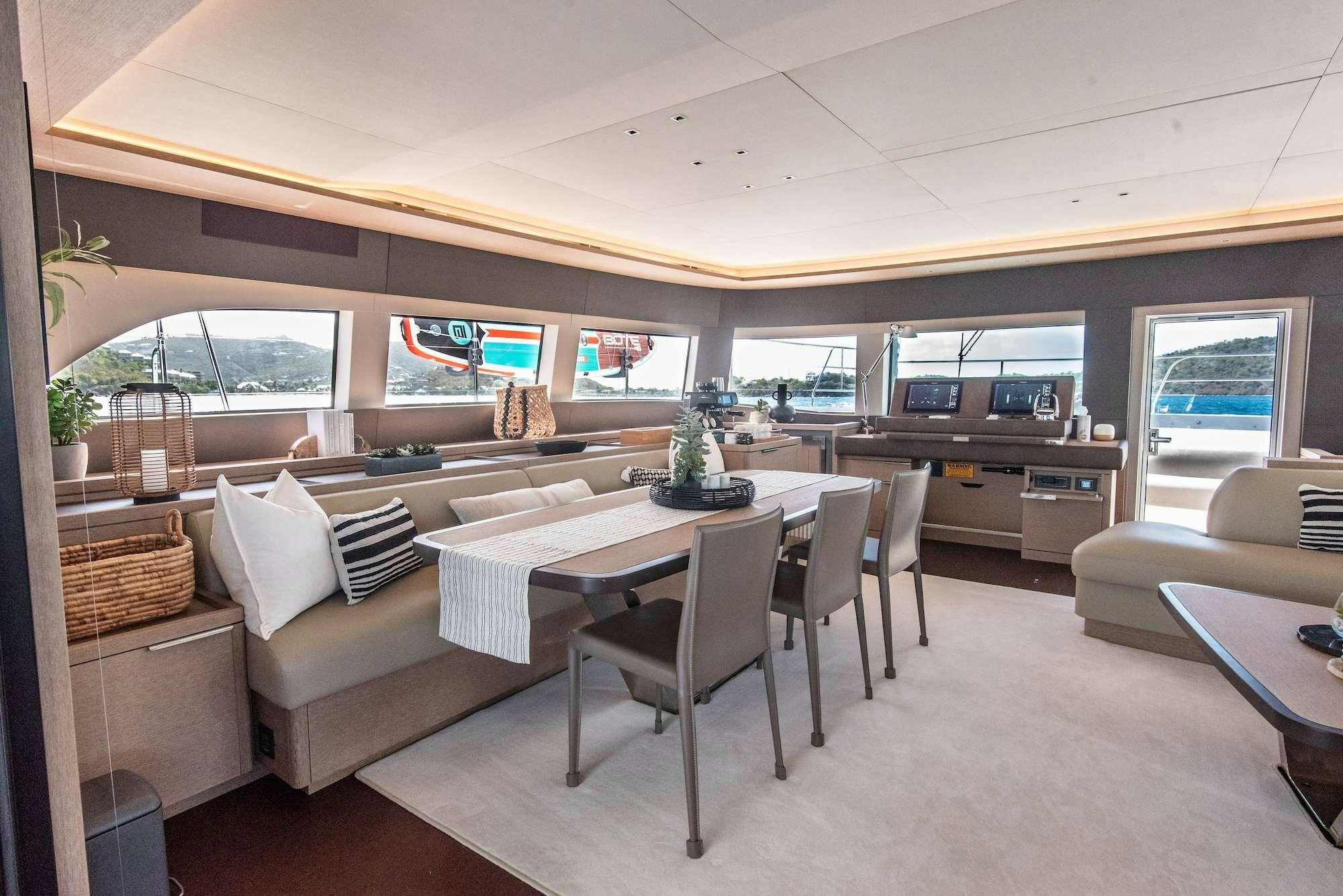 a room with a table chairs and a couch aboard C’EST LA VIE Yacht for Charter