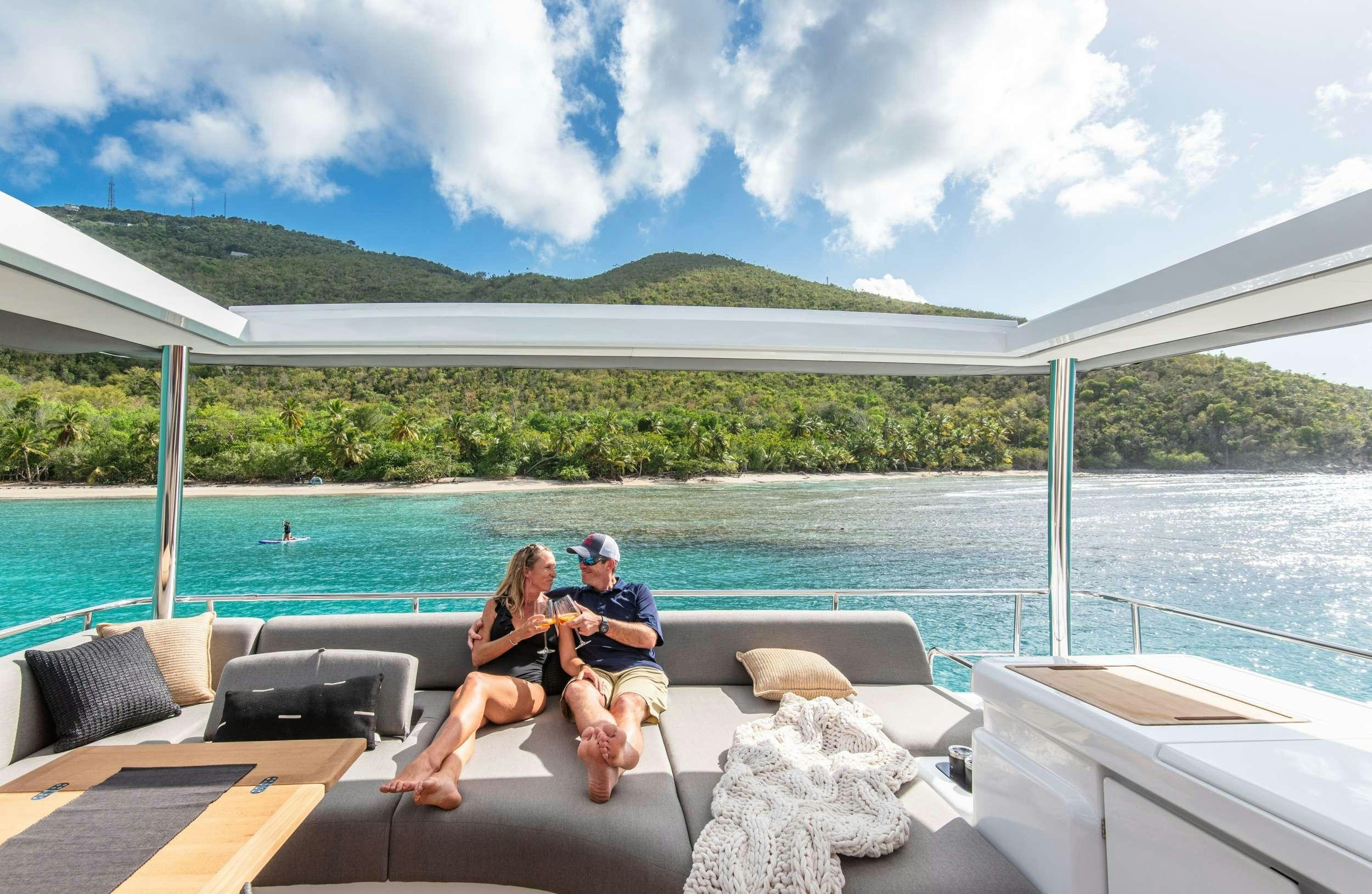 a couple sitting on a bench by a body of water aboard C’EST LA VIE Yacht for Charter