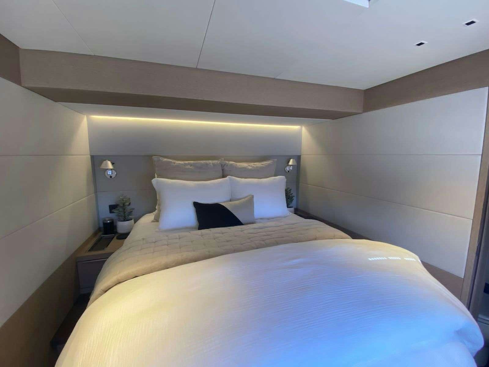 a bed with white sheets aboard C’EST LA VIE Yacht for Charter