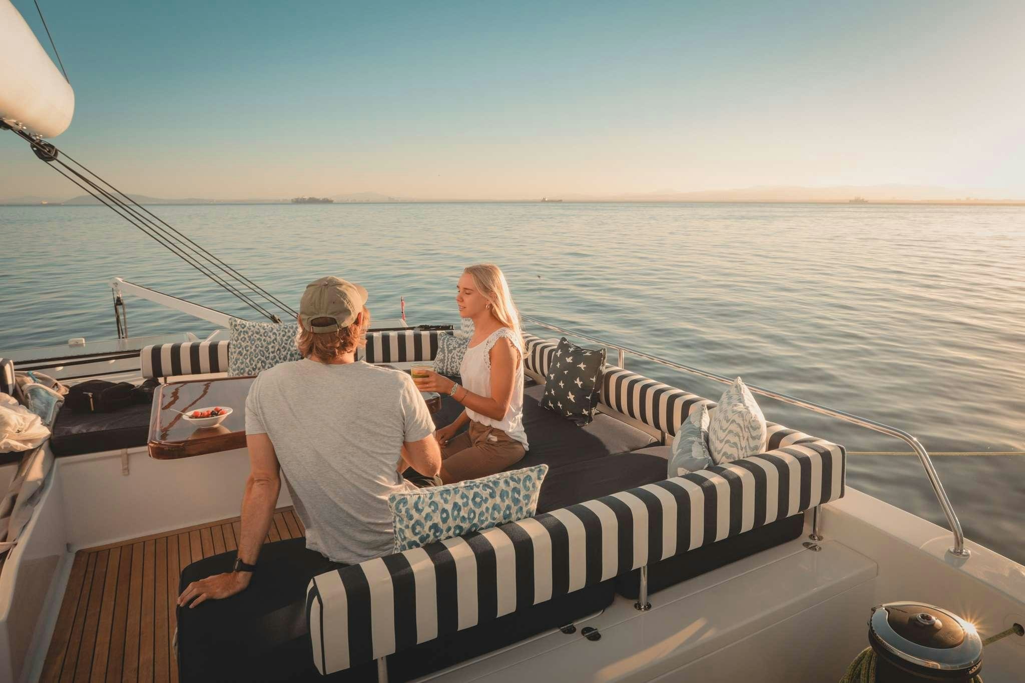a man and woman sitting on a boat in the water aboard SKIMMER Yacht for Charter
