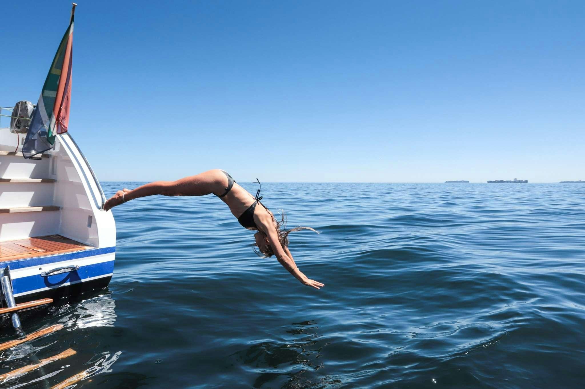a person jumping into the water aboard SKIMMER Yacht for Charter
