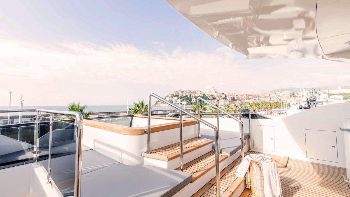 a deck with a view of the ocean and the beach aboard LADY CAROLINE Yacht for Charter