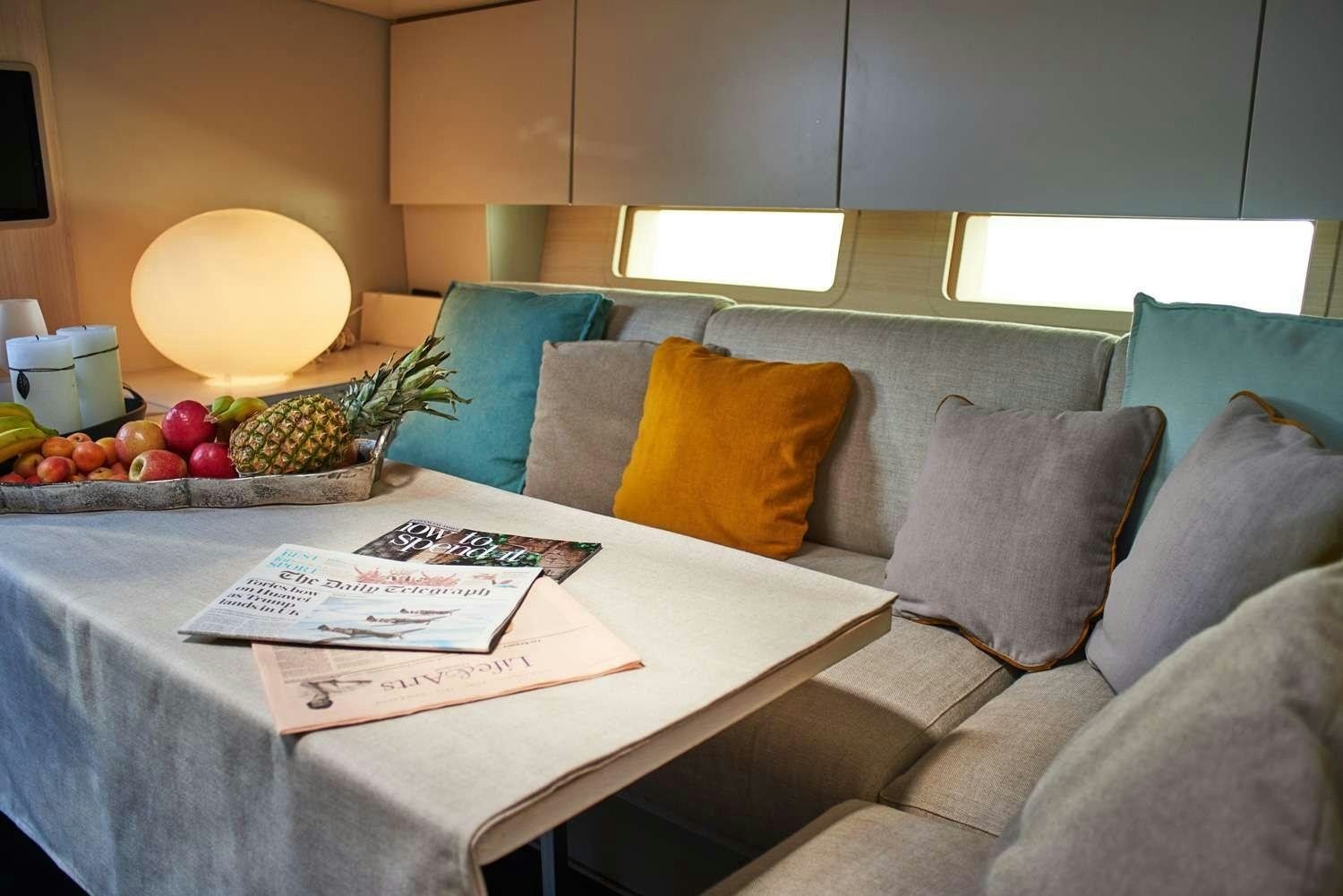 a couch and a table with fruits on it aboard AORI Yacht for Charter