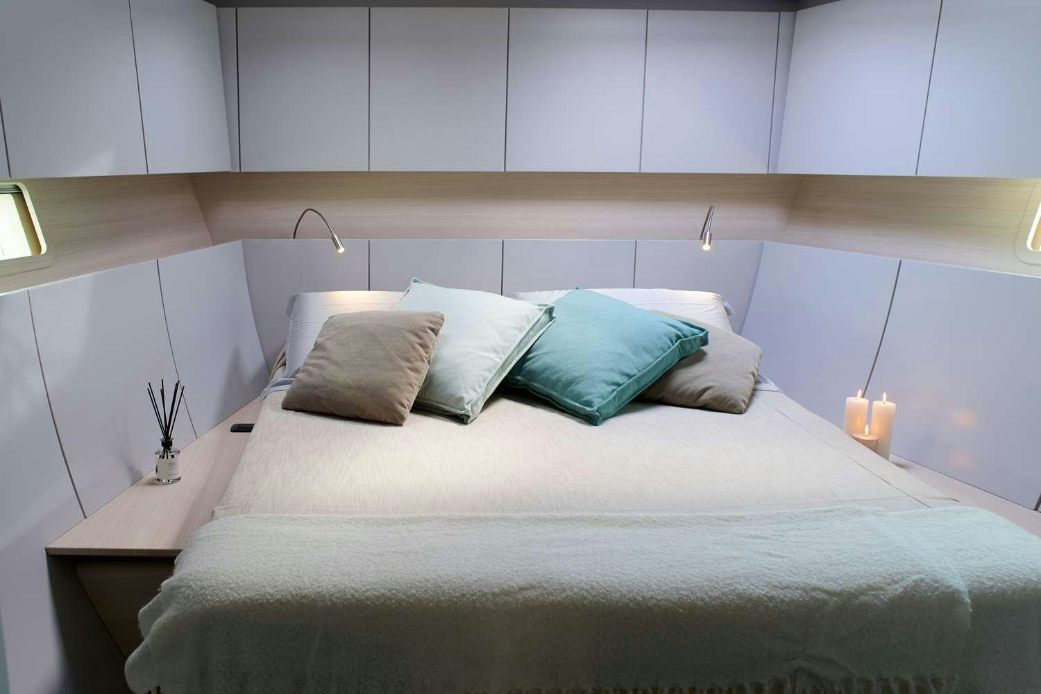 a bed with pillows aboard AORI Yacht for Charter