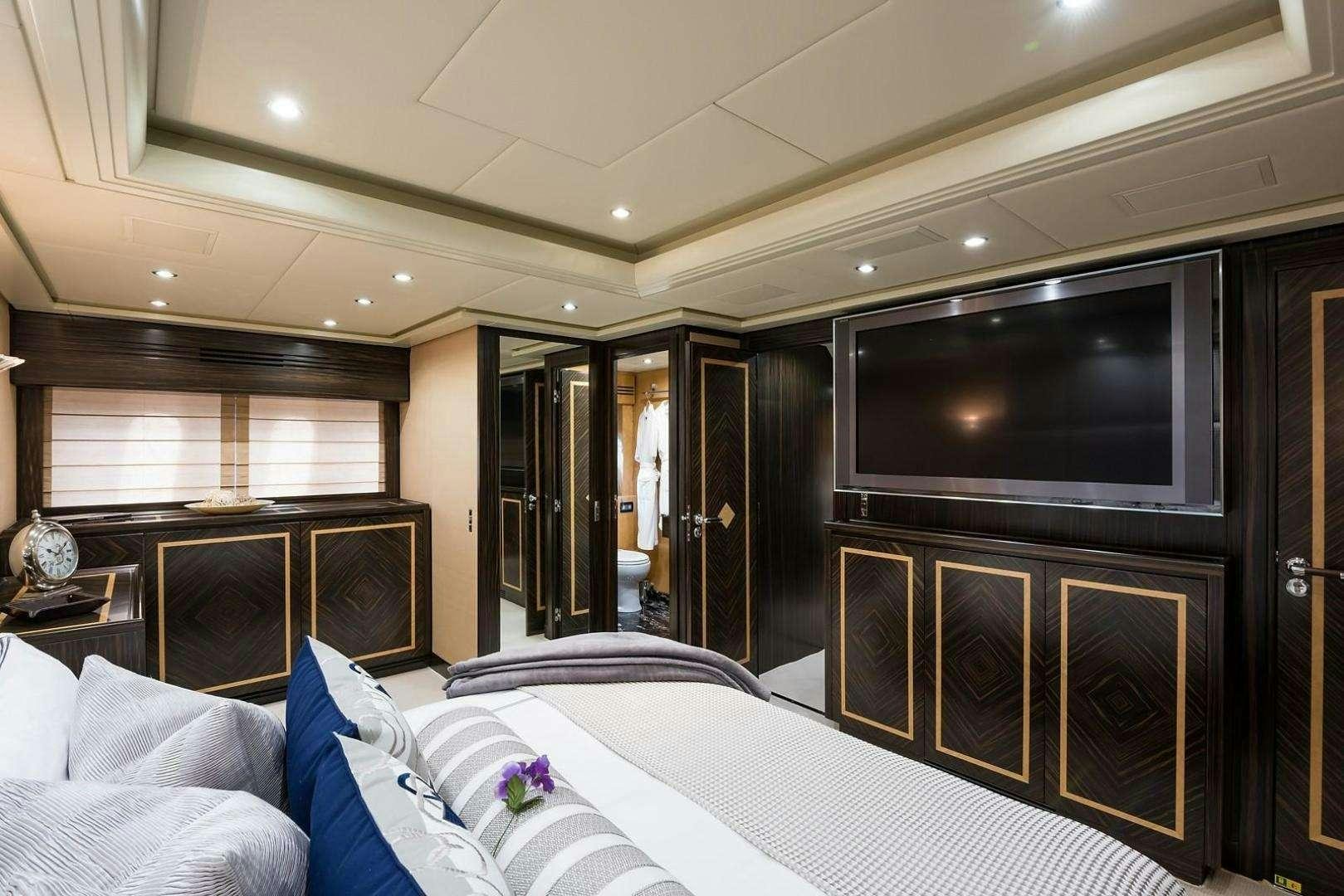 a hotel room with a bed and tv aboard ENCORE Yacht for Charter