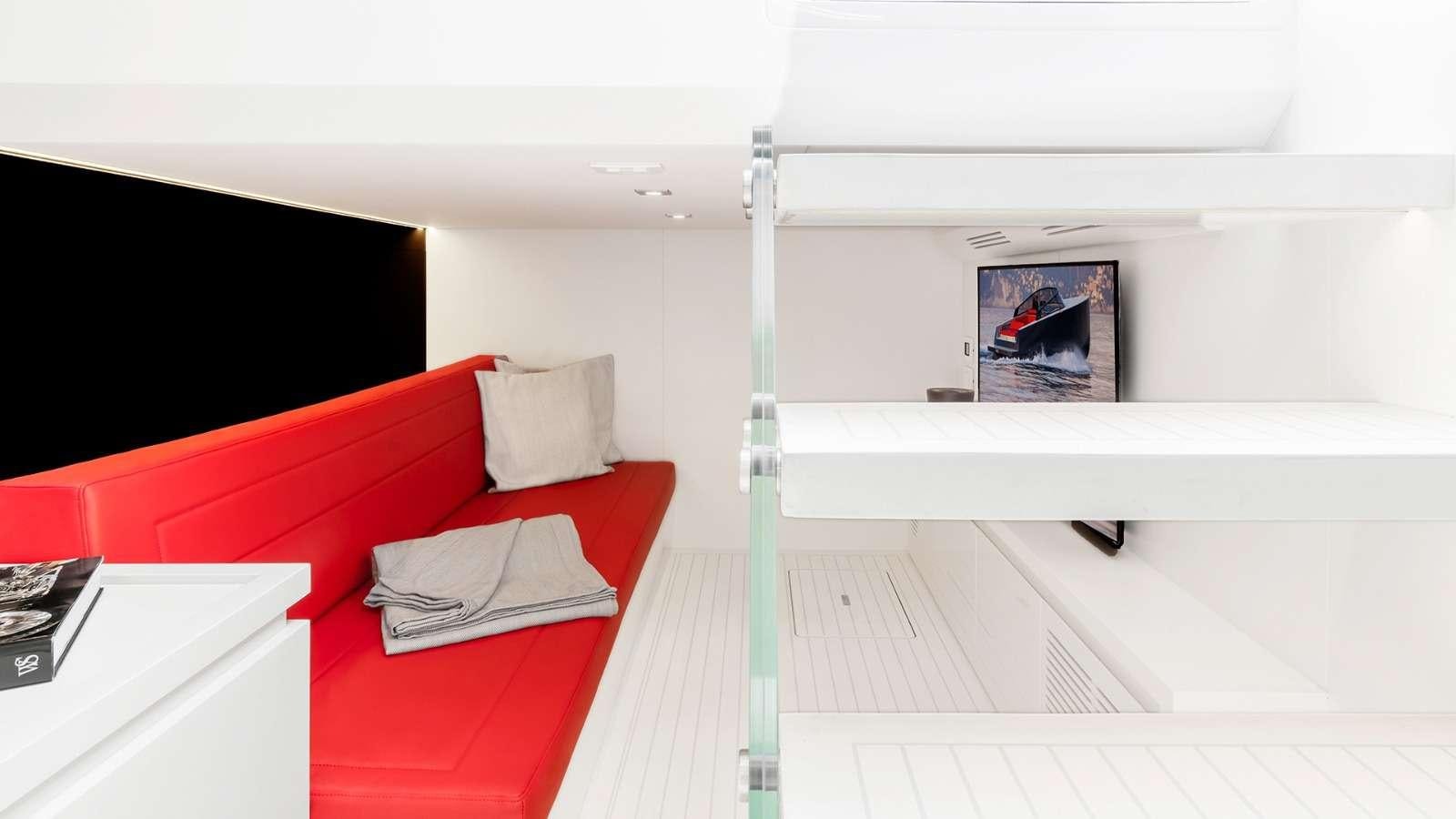 a room with a red couch and a television aboard 48 Van Dutch  Yacht for Charter