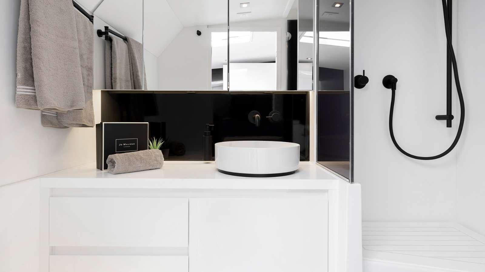 a white kitchen with a black microwave aboard 48 Van Dutch  Yacht for Charter