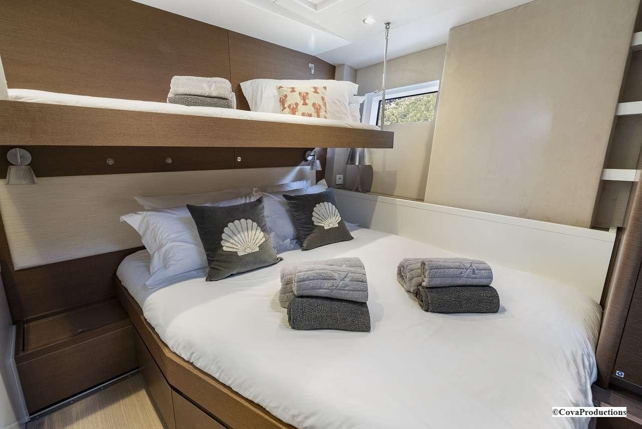 a bed with a white sheet and pillows on it aboard MAOYA Yacht for Charter