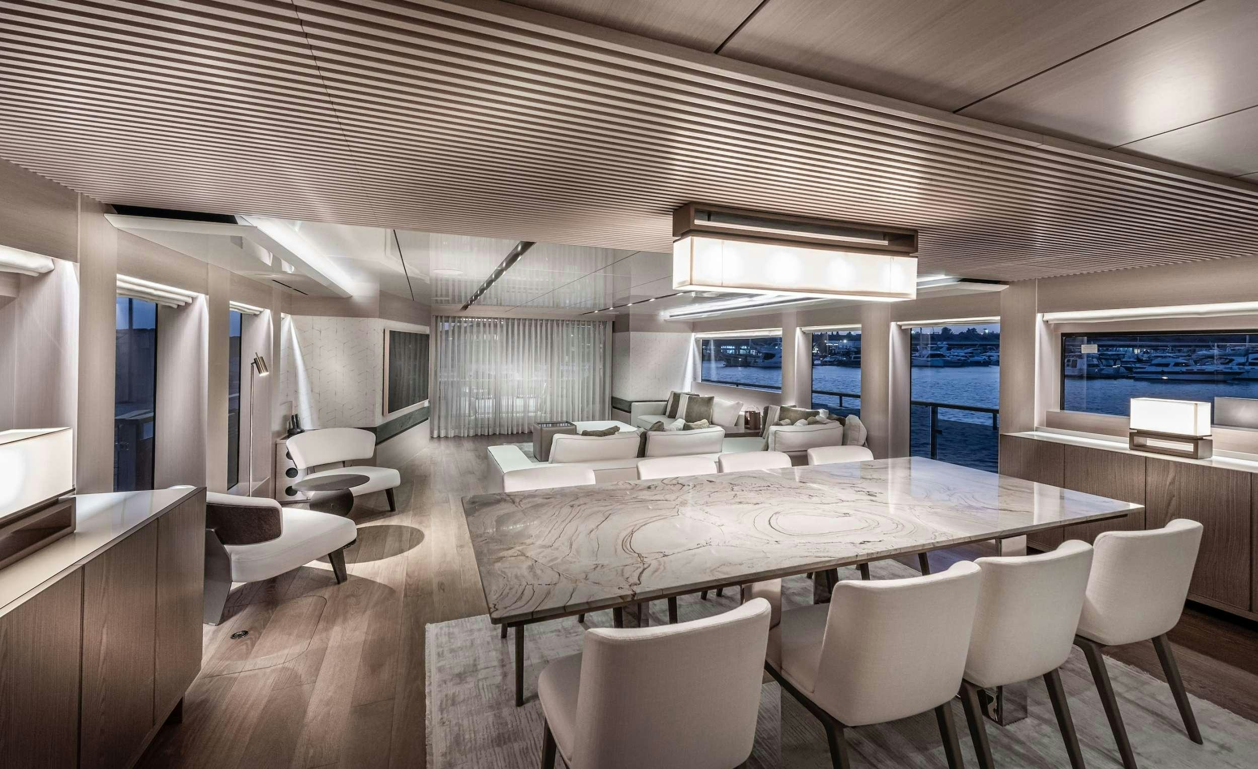 a room with a table chairs and a large window aboard ZARANIA Yacht for Charter