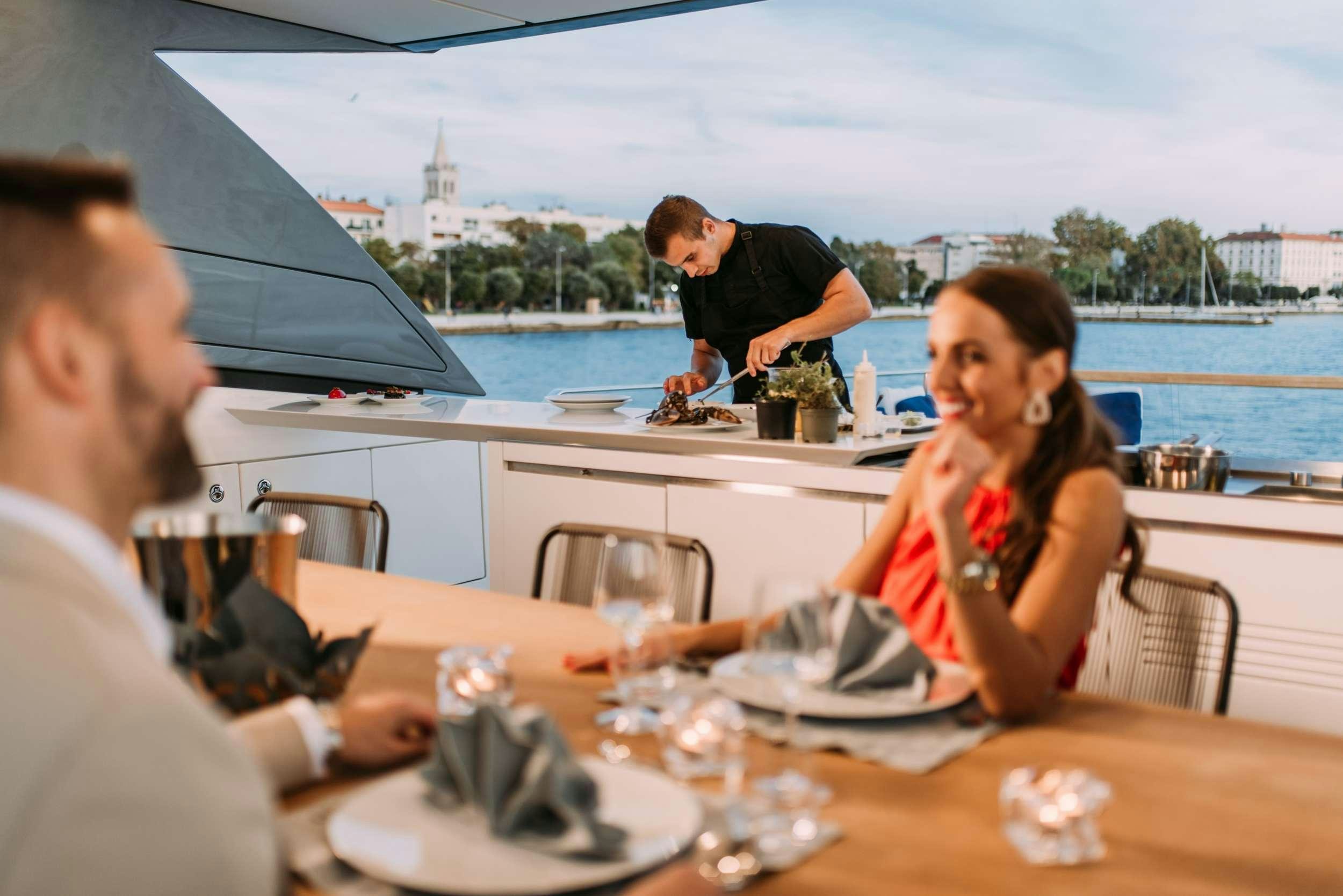 a group of people sitting at a table outside aboard ANDIAMO Yacht for Charter