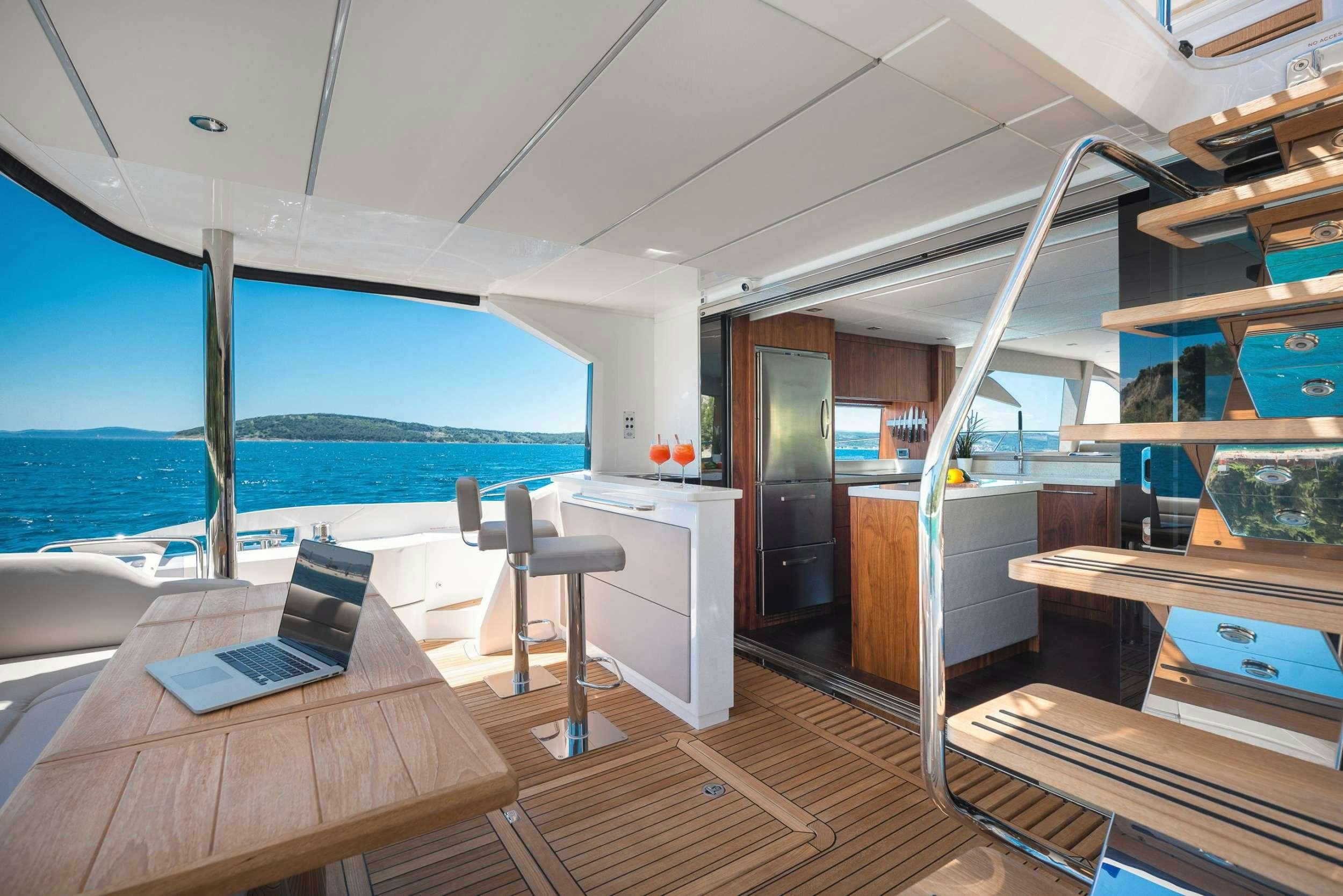 a room with a laptop and a table and chairs aboard HIDEAWAY Yacht for Charter
