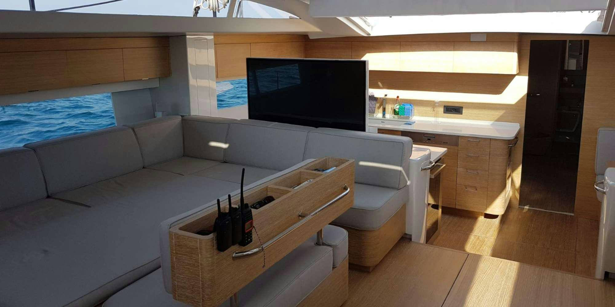 a room with a couch and a tv aboard LUCE GUIDA Yacht for Charter