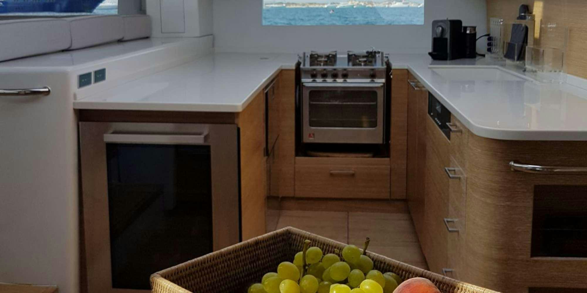 a kitchen with a microwave oven and fruit on the floor aboard LUCE GUIDA Yacht for Charter
