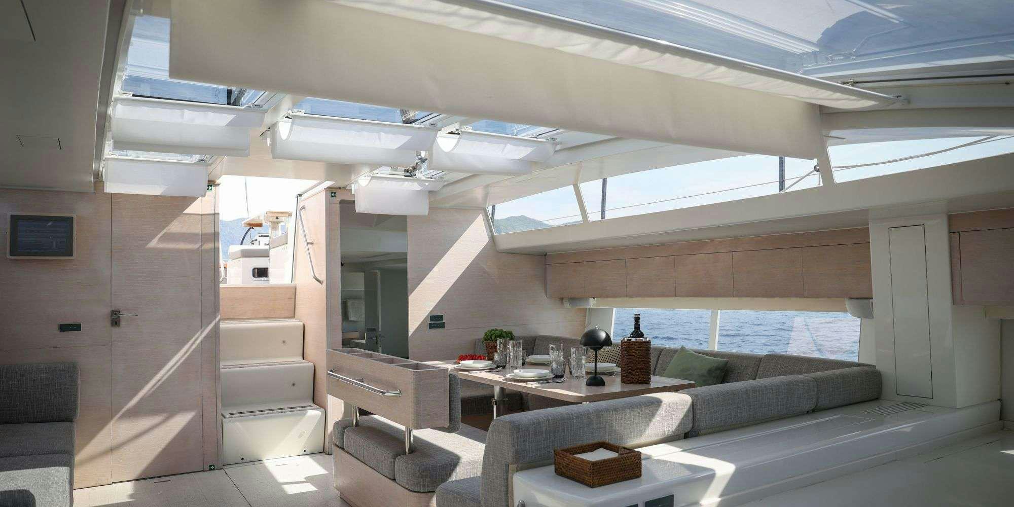 a room with a couch and a table and a window aboard LUCE GUIDA Yacht for Charter