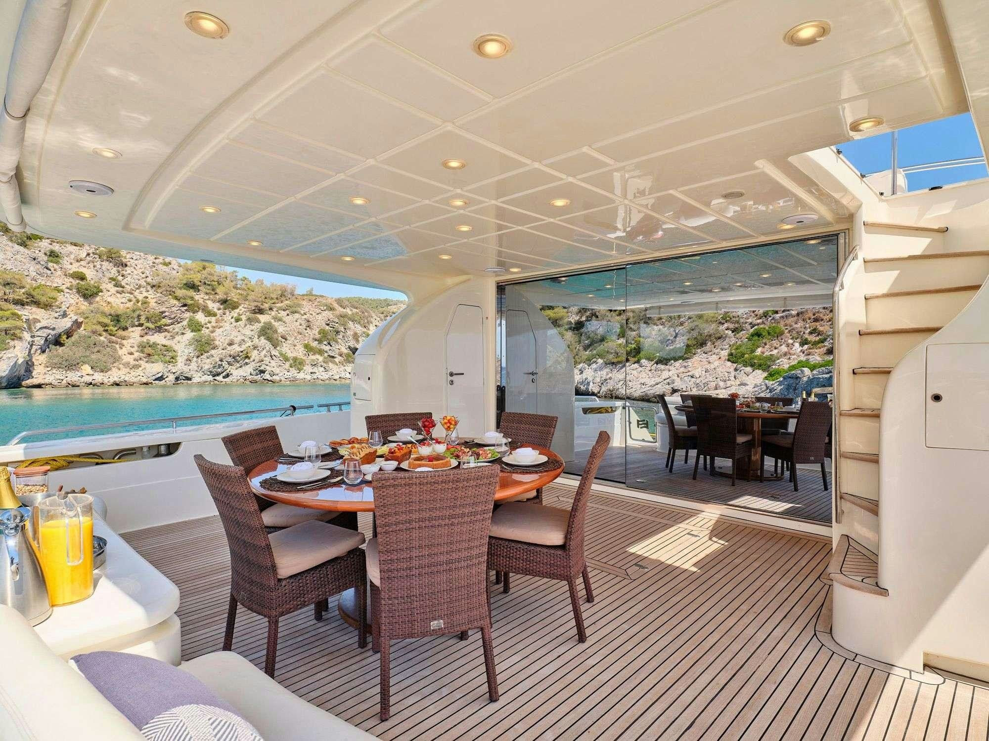 a room with a table chairs and a pool aboard ESTIA YI Yacht for Charter