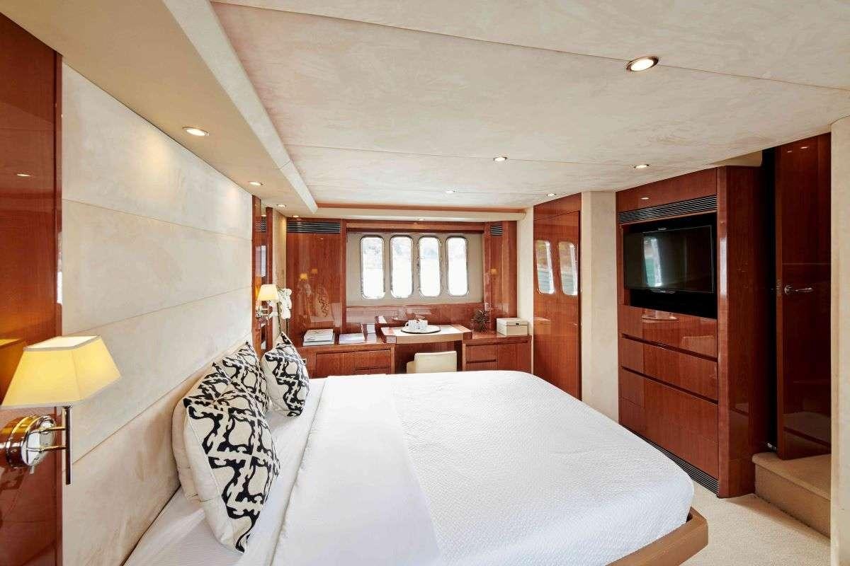 a hotel room with a bed and a television aboard ESTIA ONE Yacht for Charter