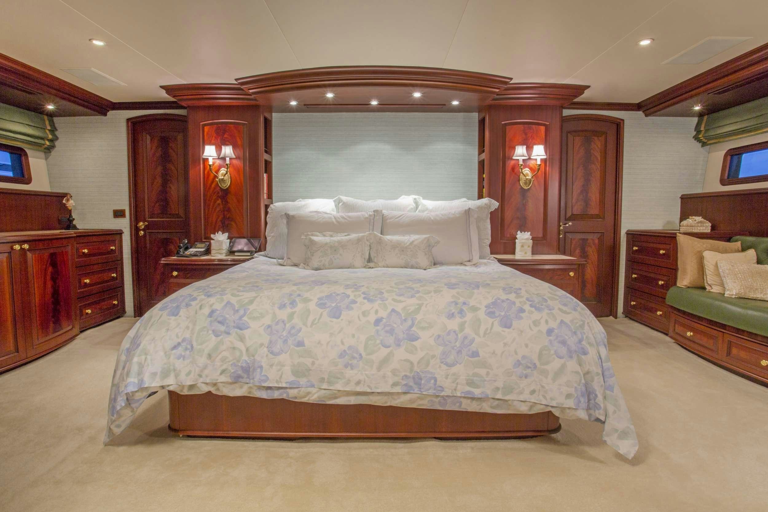 a bed with a blue comforter aboard STARLIGHT Yacht for Charter