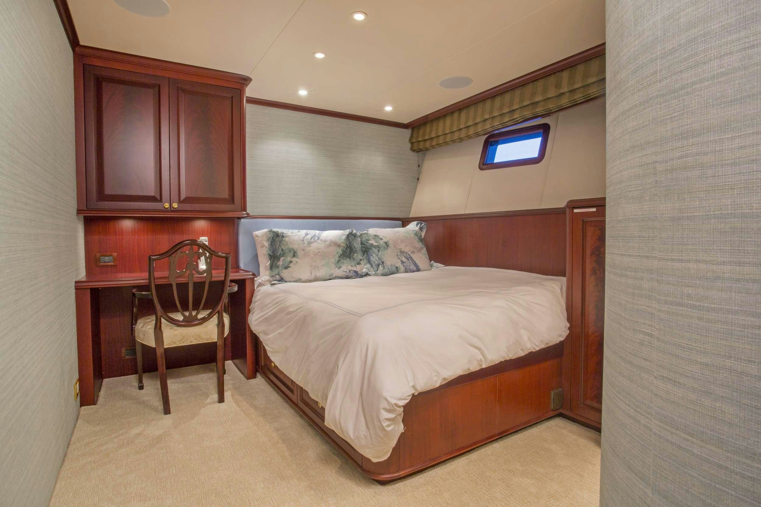 a bedroom with a bed and a chair aboard STARLIGHT Yacht for Charter