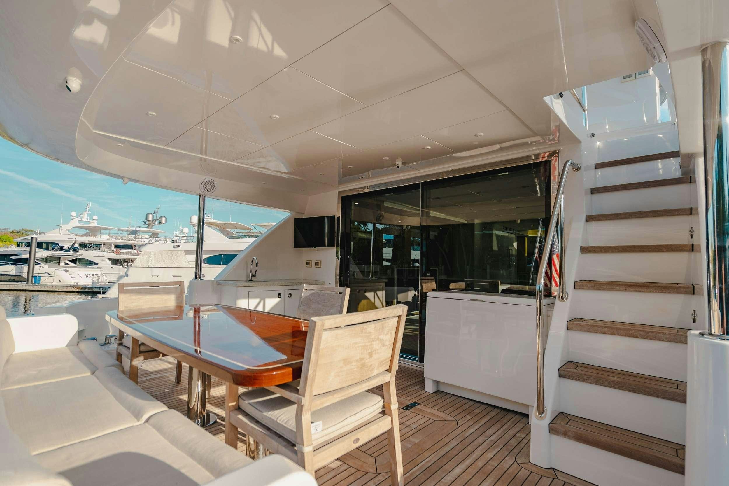 a room with a table chairs and a staircase aboard BELLA SKY Yacht for Charter