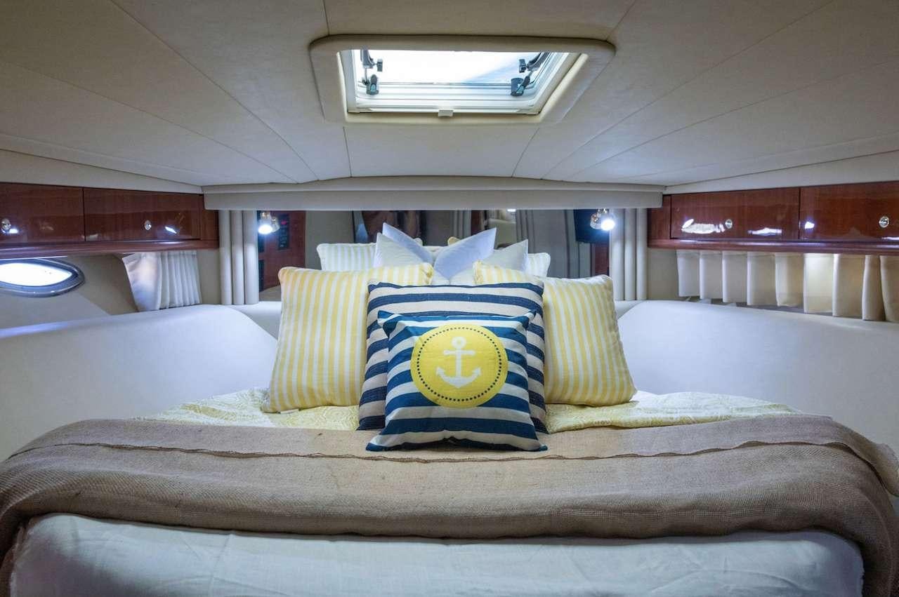 a bed with pillows aboard Low Profile Yacht for Charter