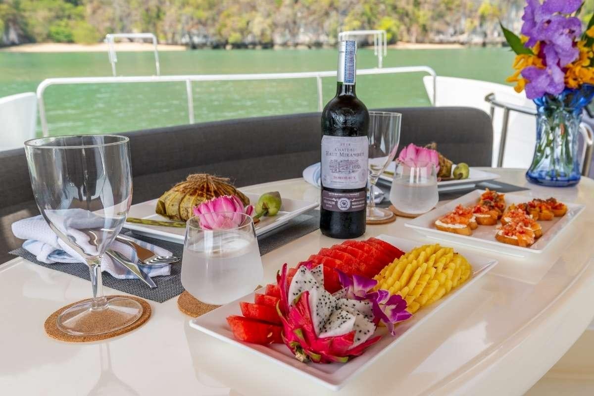 a table with food and wine aboard 137 PILLARS SPIRIT Yacht for Charter