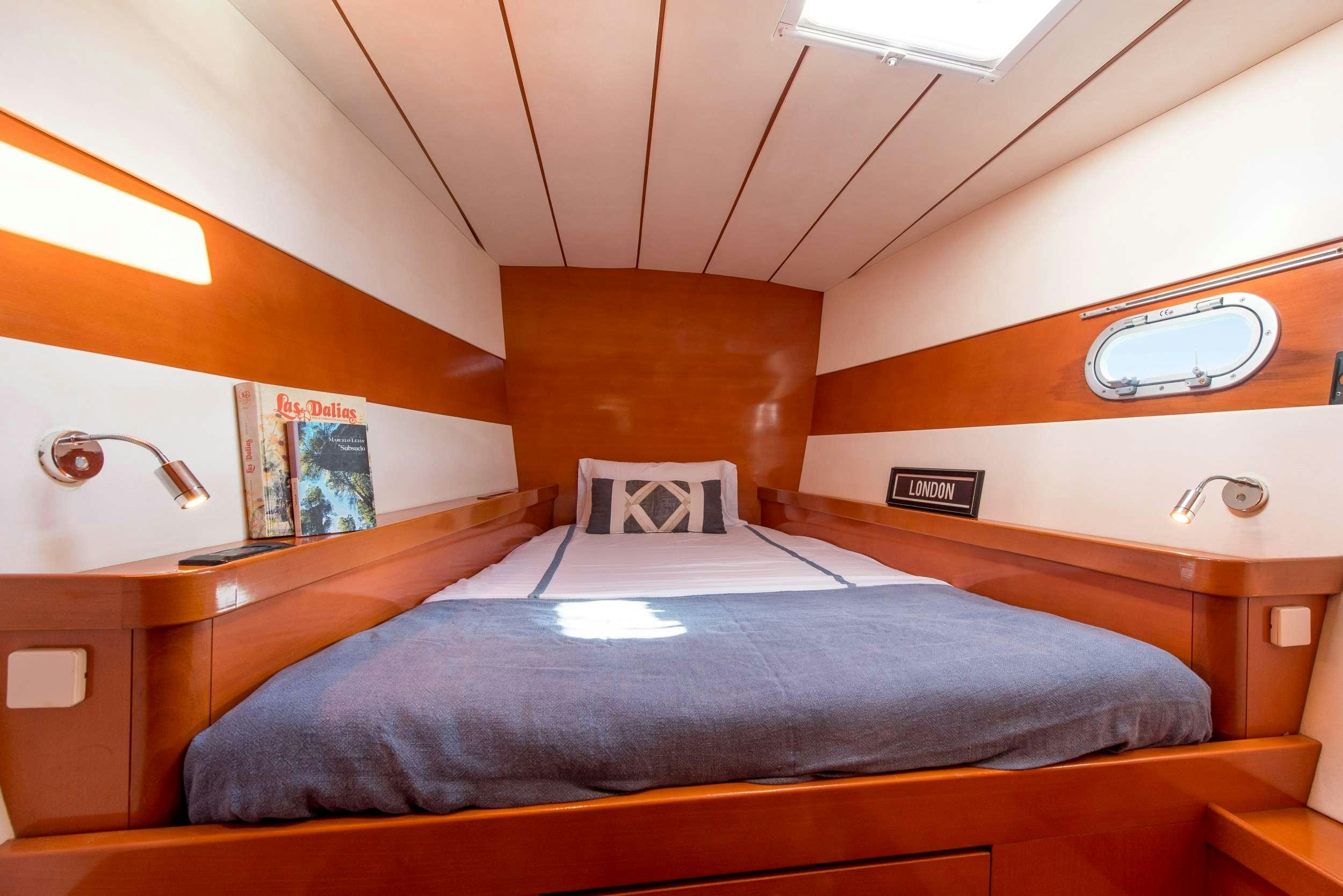 a bed with a blue comforter aboard JOVA Yacht for Charter
