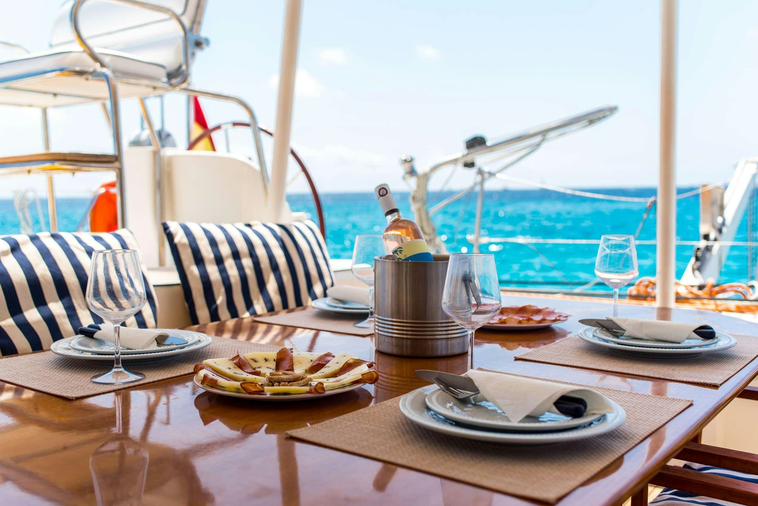 a table with plates and food on it aboard JOVA Yacht for Charter