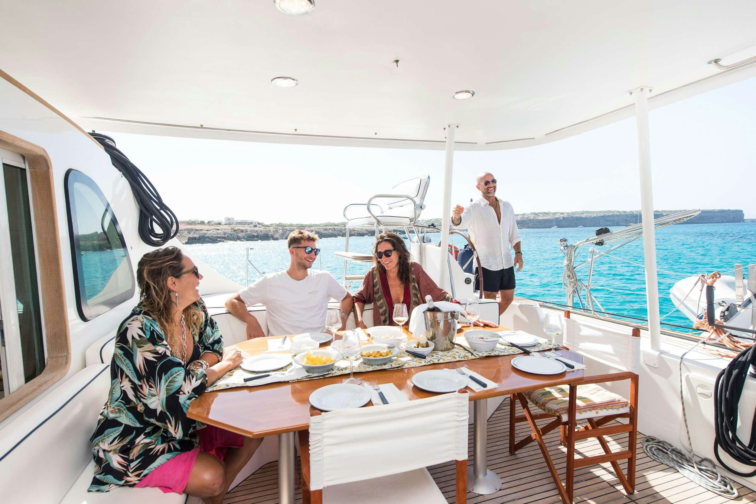 a group of people sitting around a table on a boat aboard JOVA Yacht for Charter