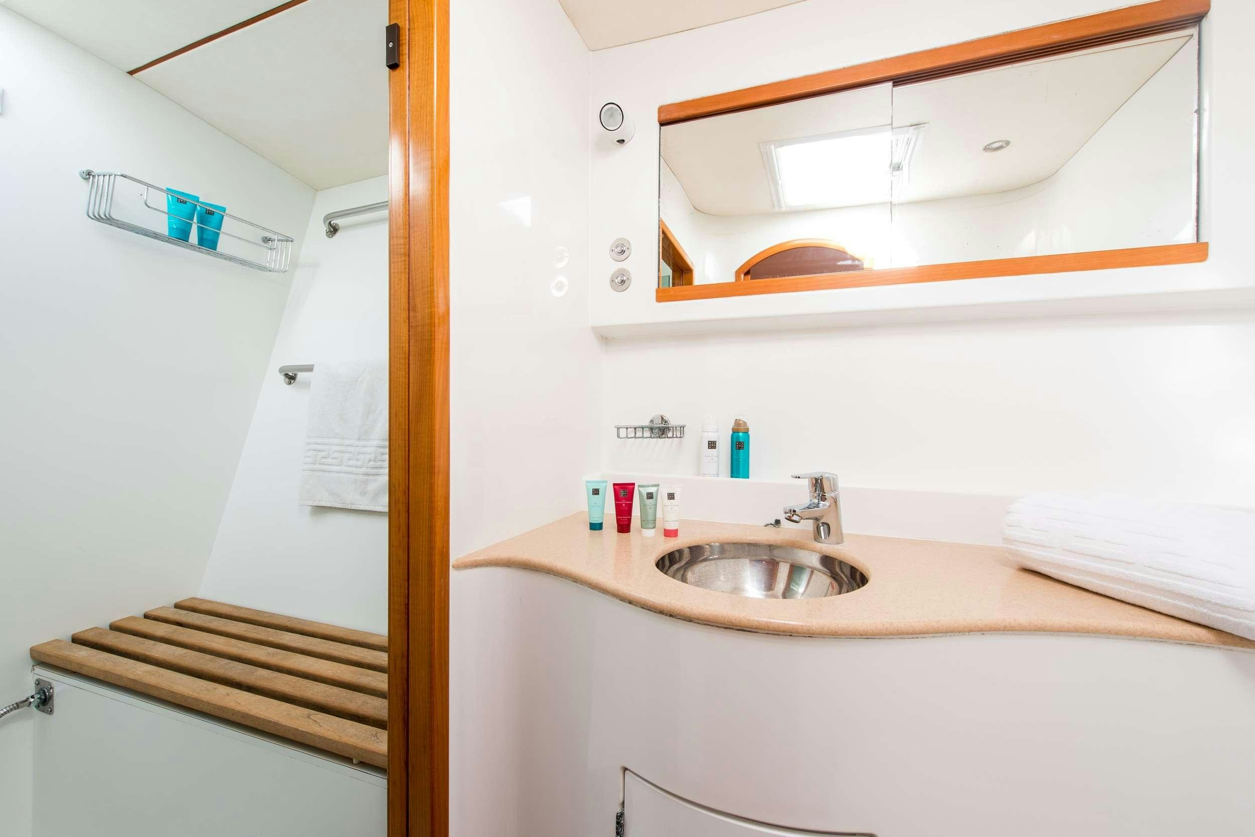 a bathroom with a sink and a shelf aboard JOVA Yacht for Charter