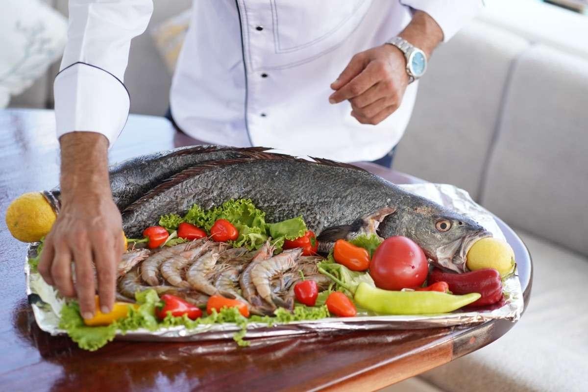 a person holding a tray of food aboard PRENSES ESILA Yacht for Charter