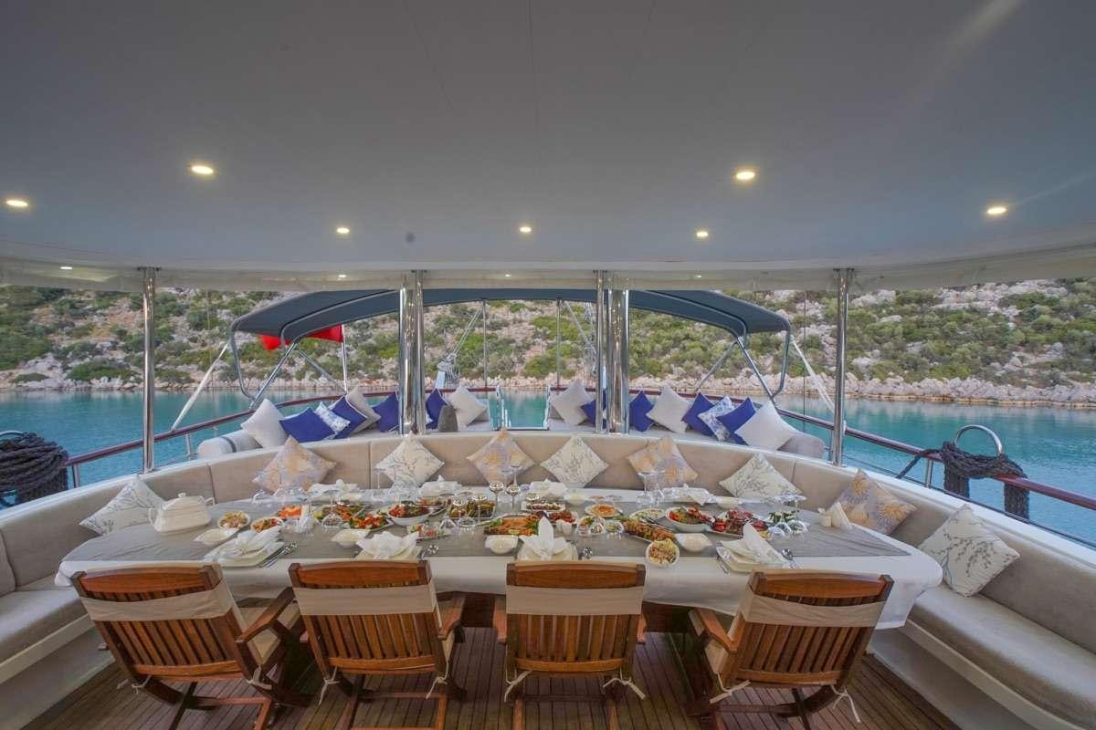 a table with chairs and umbrellas on it aboard PRENSES ESILA Yacht for Charter