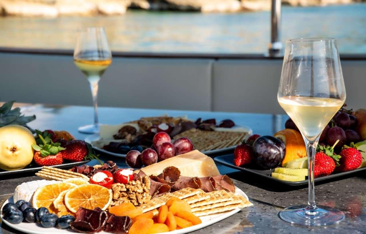 a plate of fruit and a glass of wine aboard MERIDIAN ADVENTURE Yacht for Charter