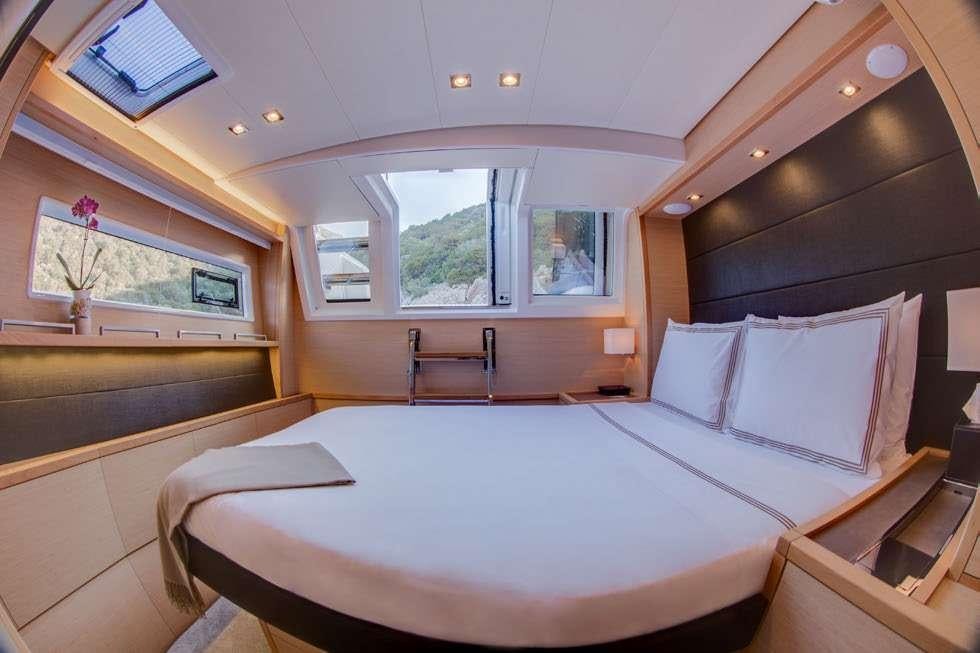 a room with a bed and a chair aboard MERIDIAN ADVENTURE Yacht for Charter
