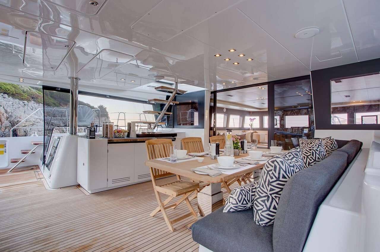 a room with a couch and a table and chairs aboard MERIDIAN ADVENTURE - RAJA AMPAT Yacht for Charter