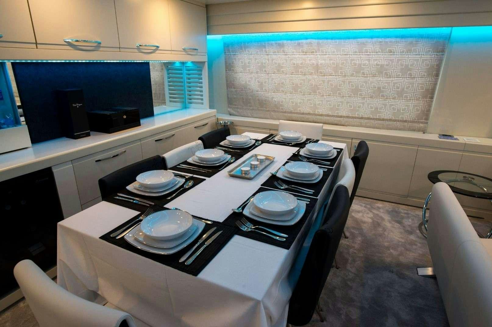 a table with plates and a laptop on it aboard ANDROMEDA Yacht for Charter