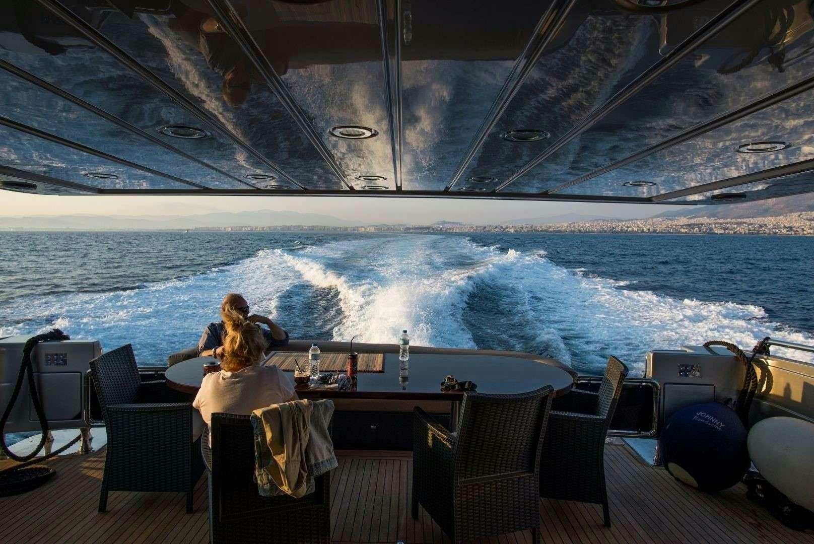 a couple sitting at a table with a view of the ocean aboard ANDROMEDA Yacht for Charter