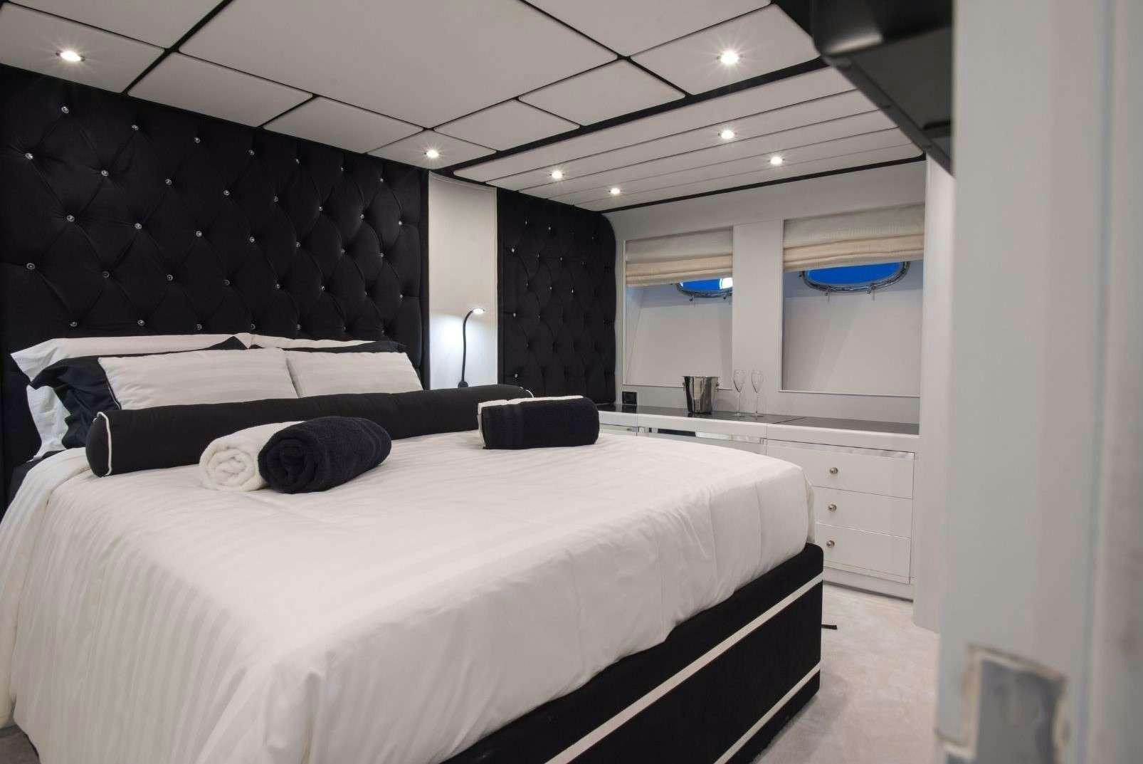 a bedroom with a bed and a chair aboard ANDROMEDA Yacht for Charter