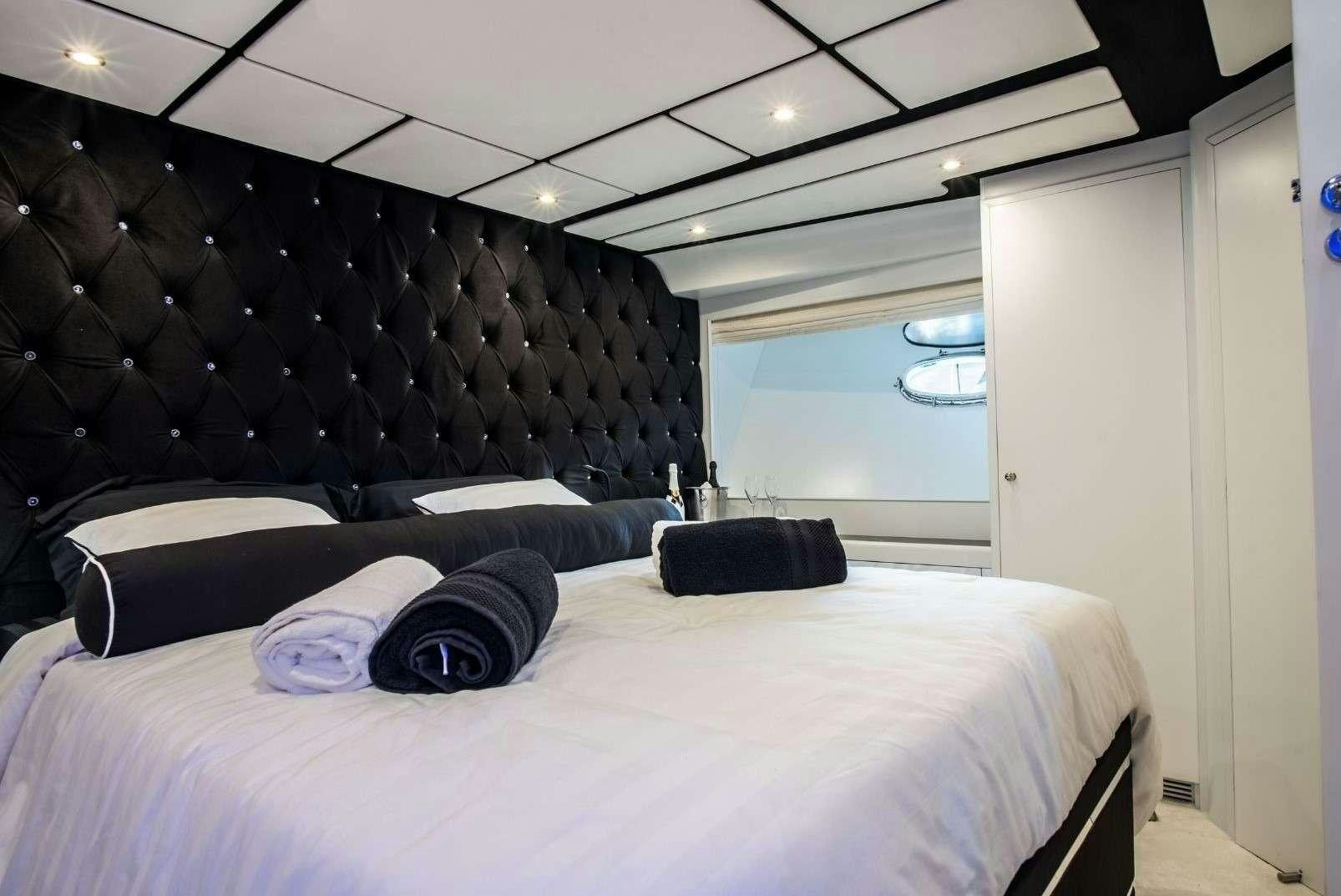 a room with a bed and a large window aboard ANDROMEDA Yacht for Charter