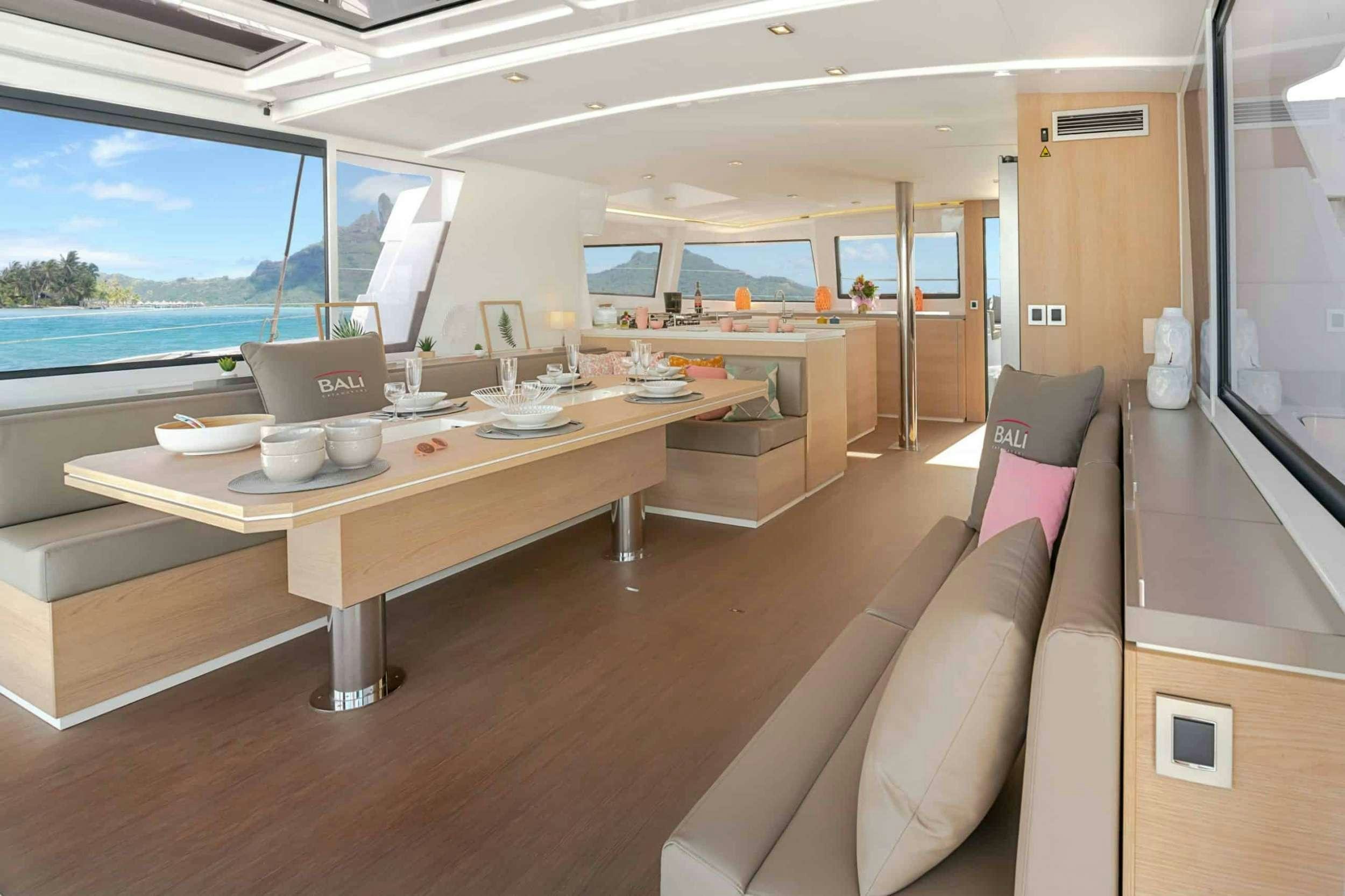 a room with a table and couches aboard Kos 54.Cat (Athens) Yacht for Charter