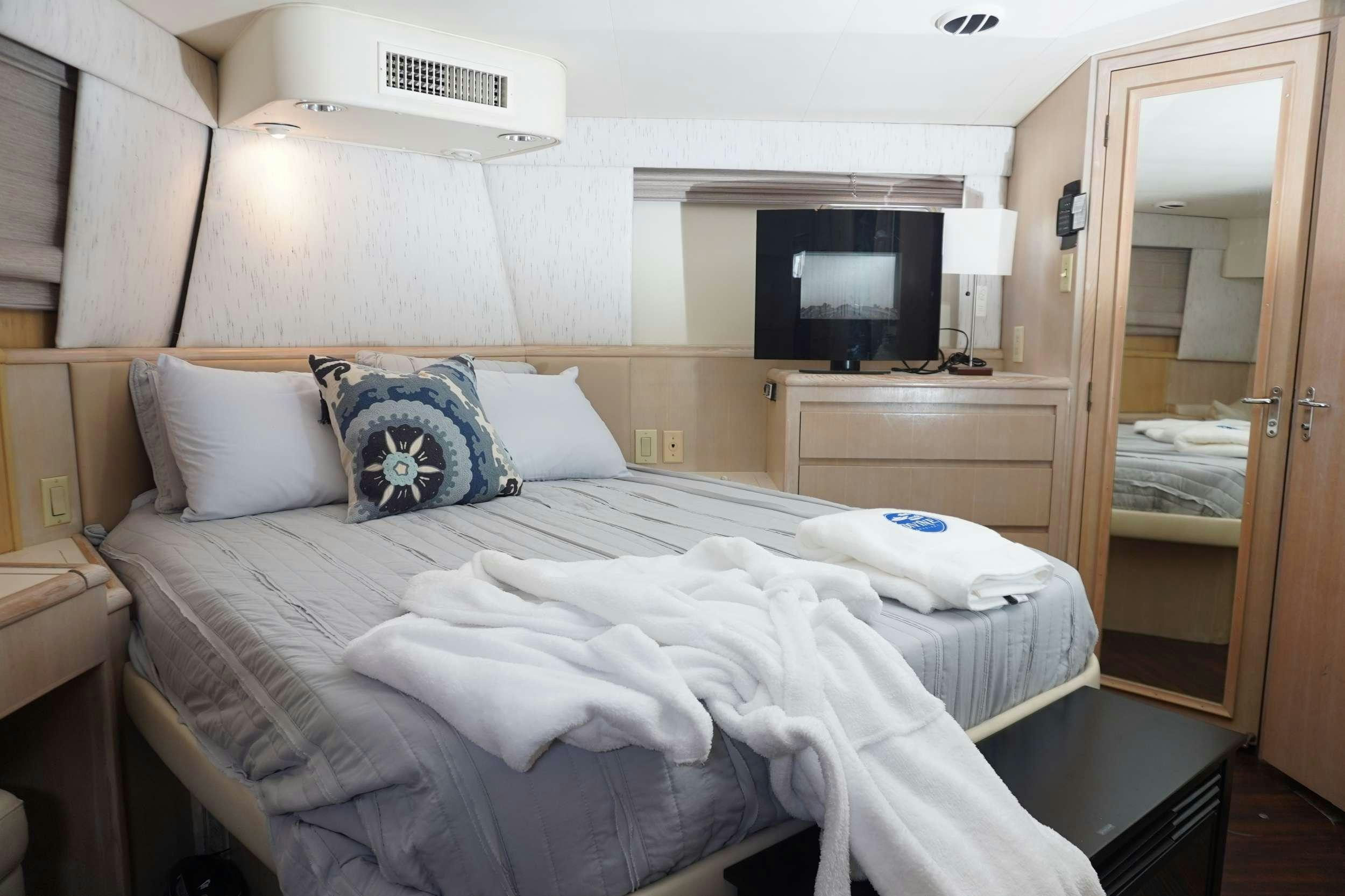a hotel room with a bed and television aboard DIVINE Yacht for Charter
