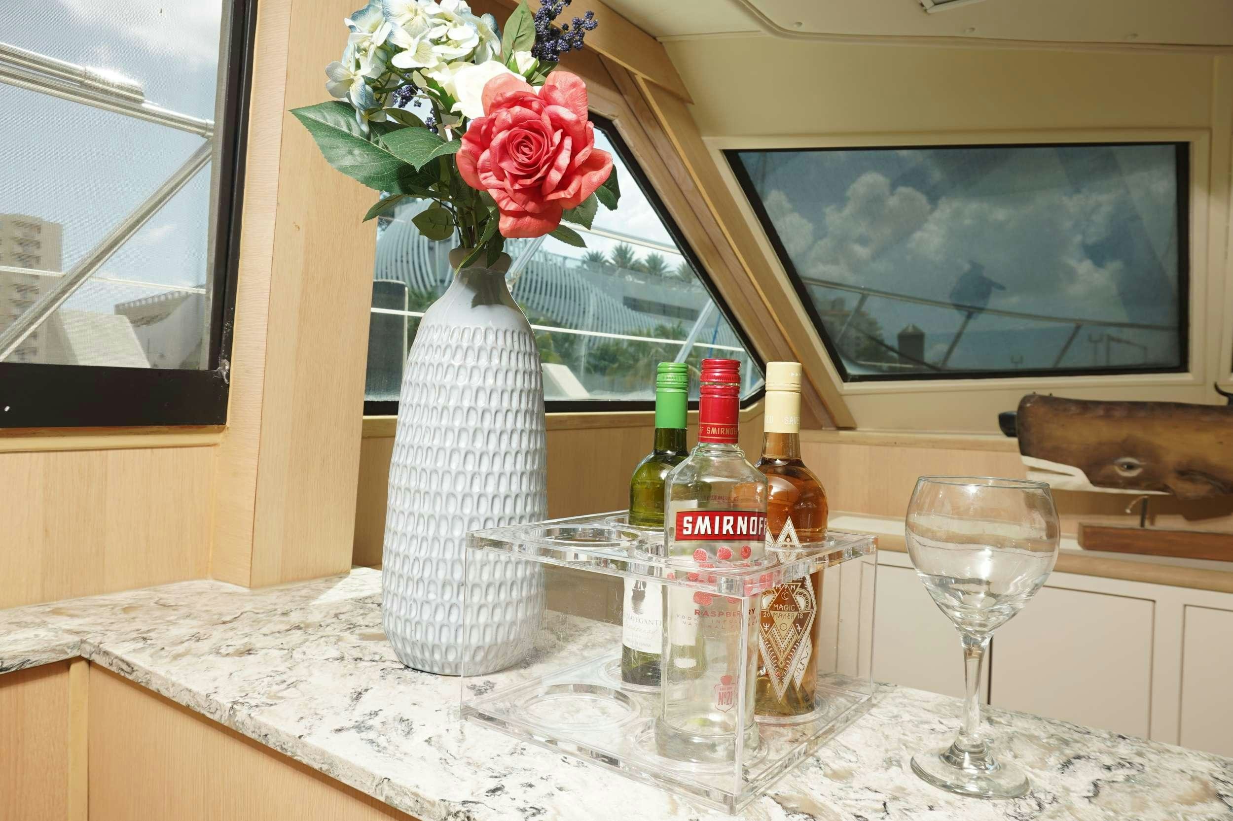 a vase of flowers next to a bottle of wine aboard DIVINE Yacht for Charter