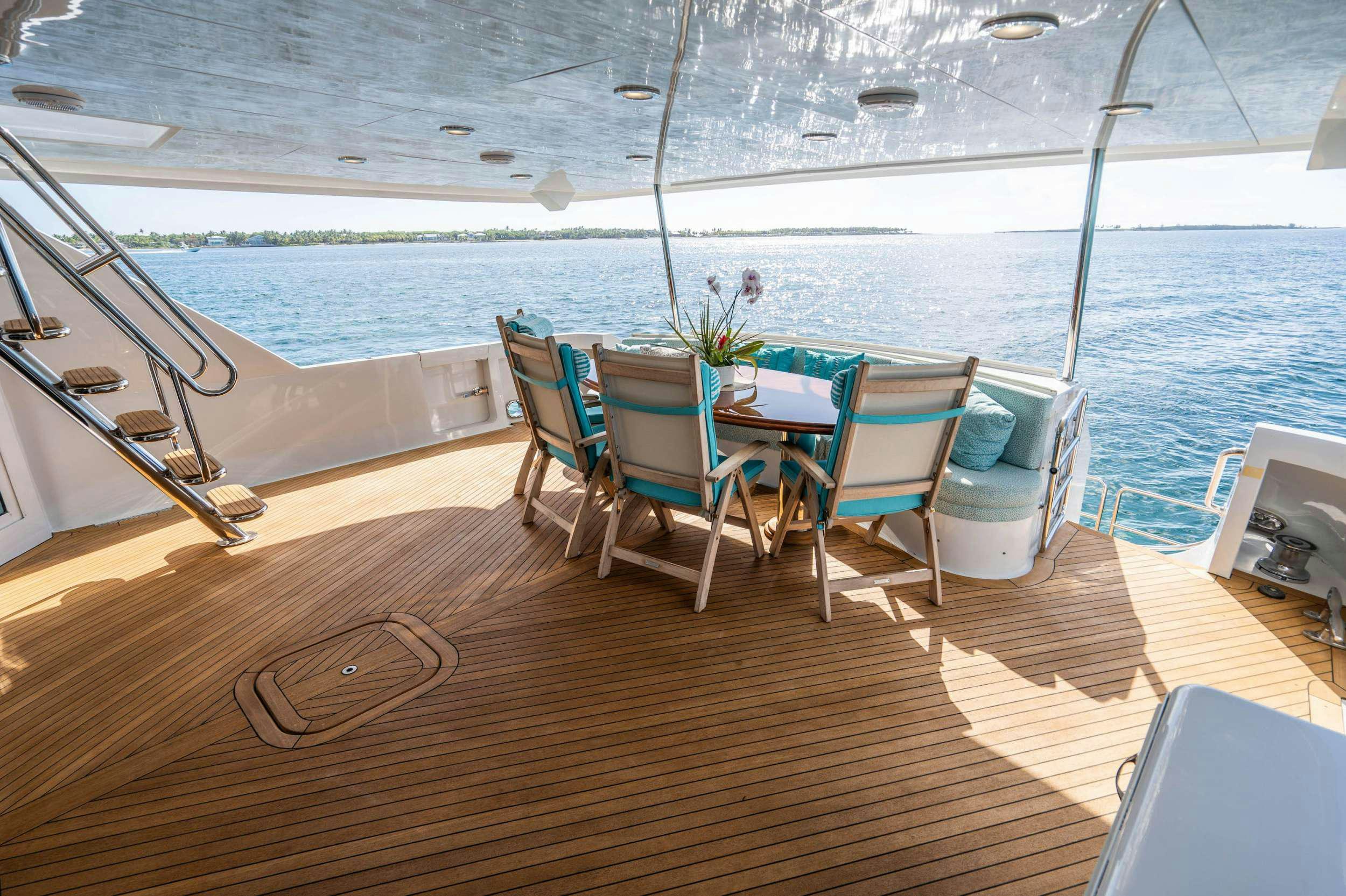 a deck with a table and chairs on it aboard CENTODUE Yacht for Charter