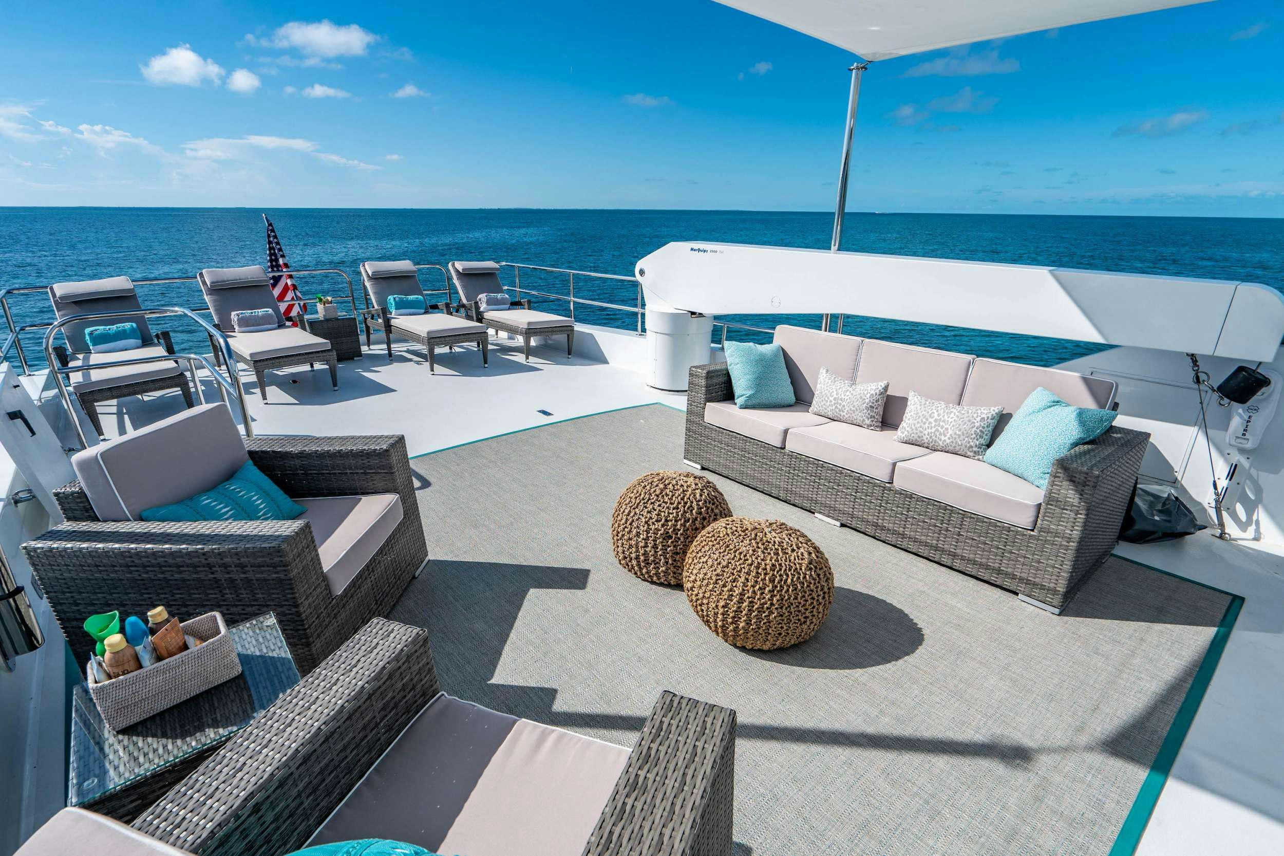 a deck with a couch and chairs aboard CENTODUE Yacht for Charter