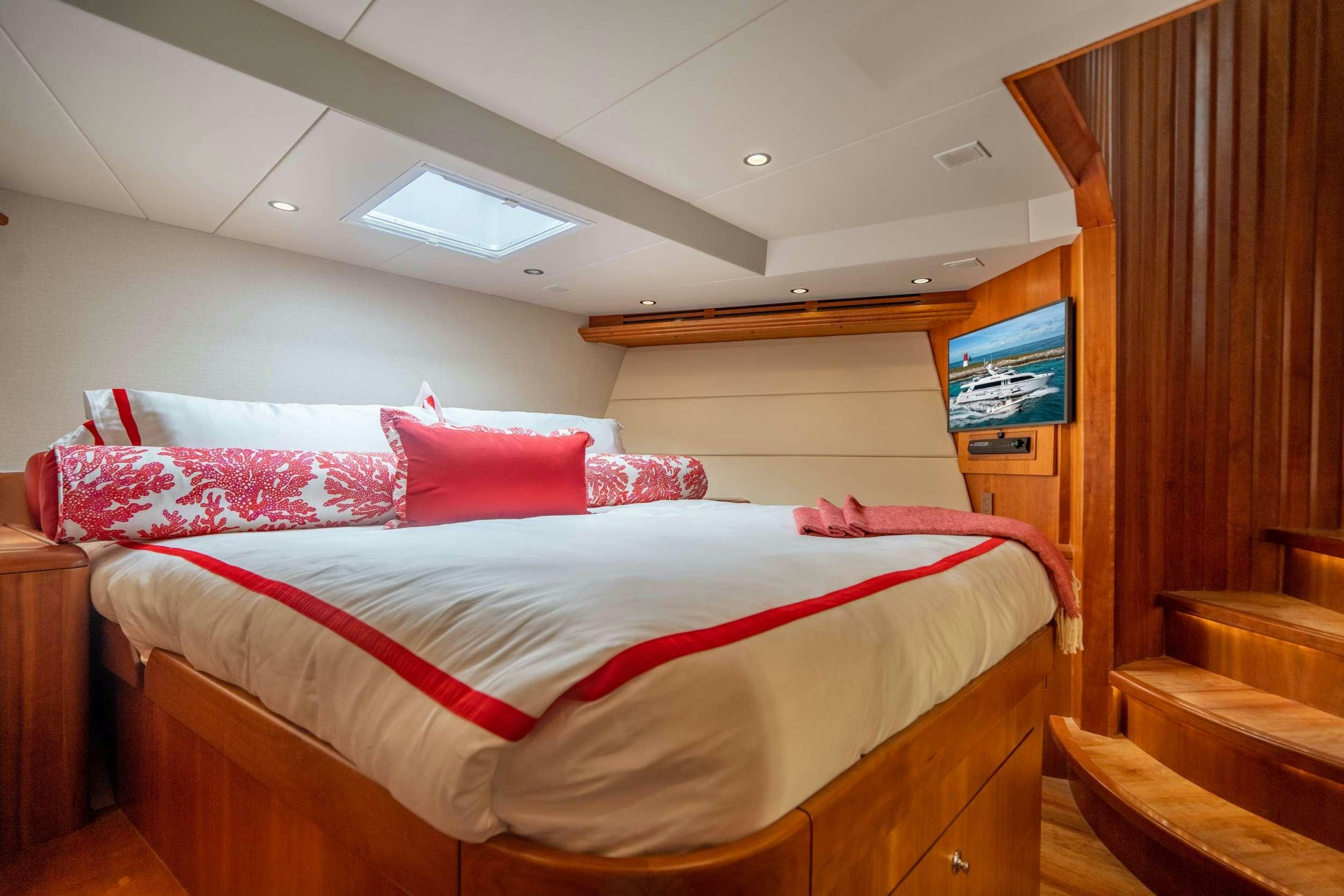 a bed with red pillows aboard CENTODUE Yacht for Charter