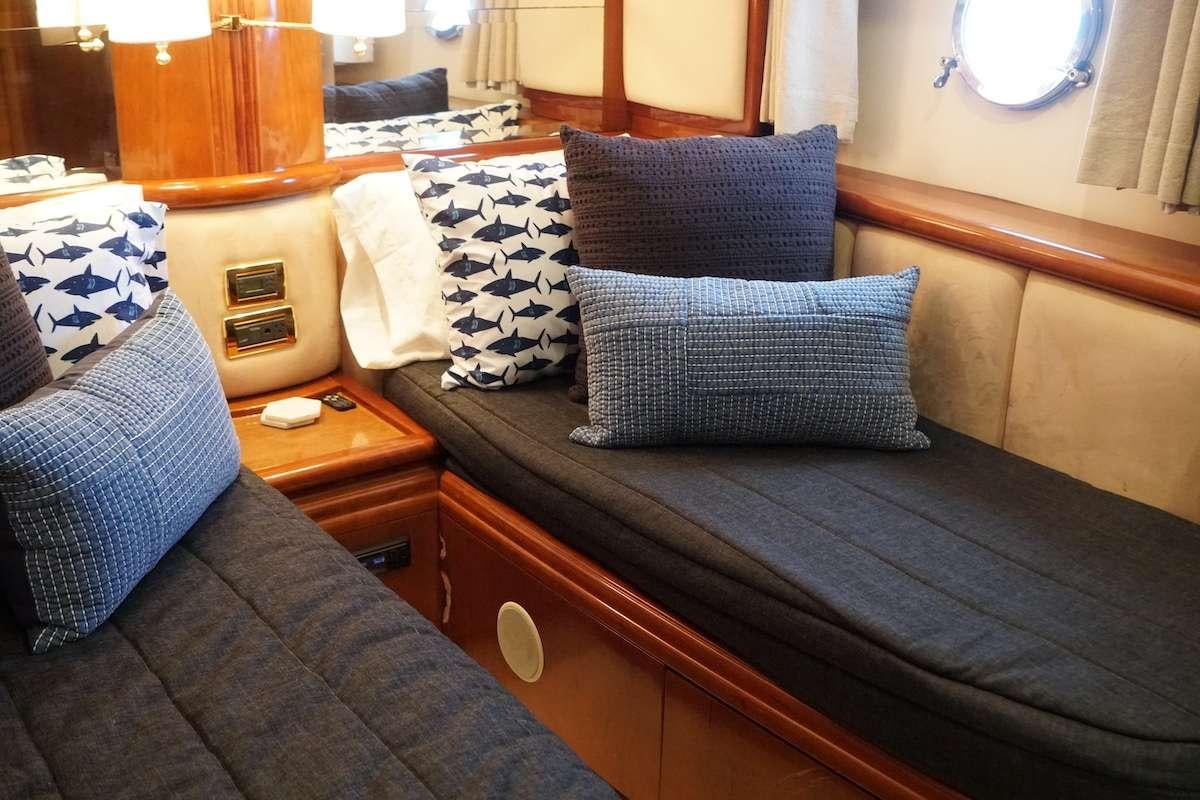 a bed with pillows and a dresser aboard AZURE Yacht for Charter