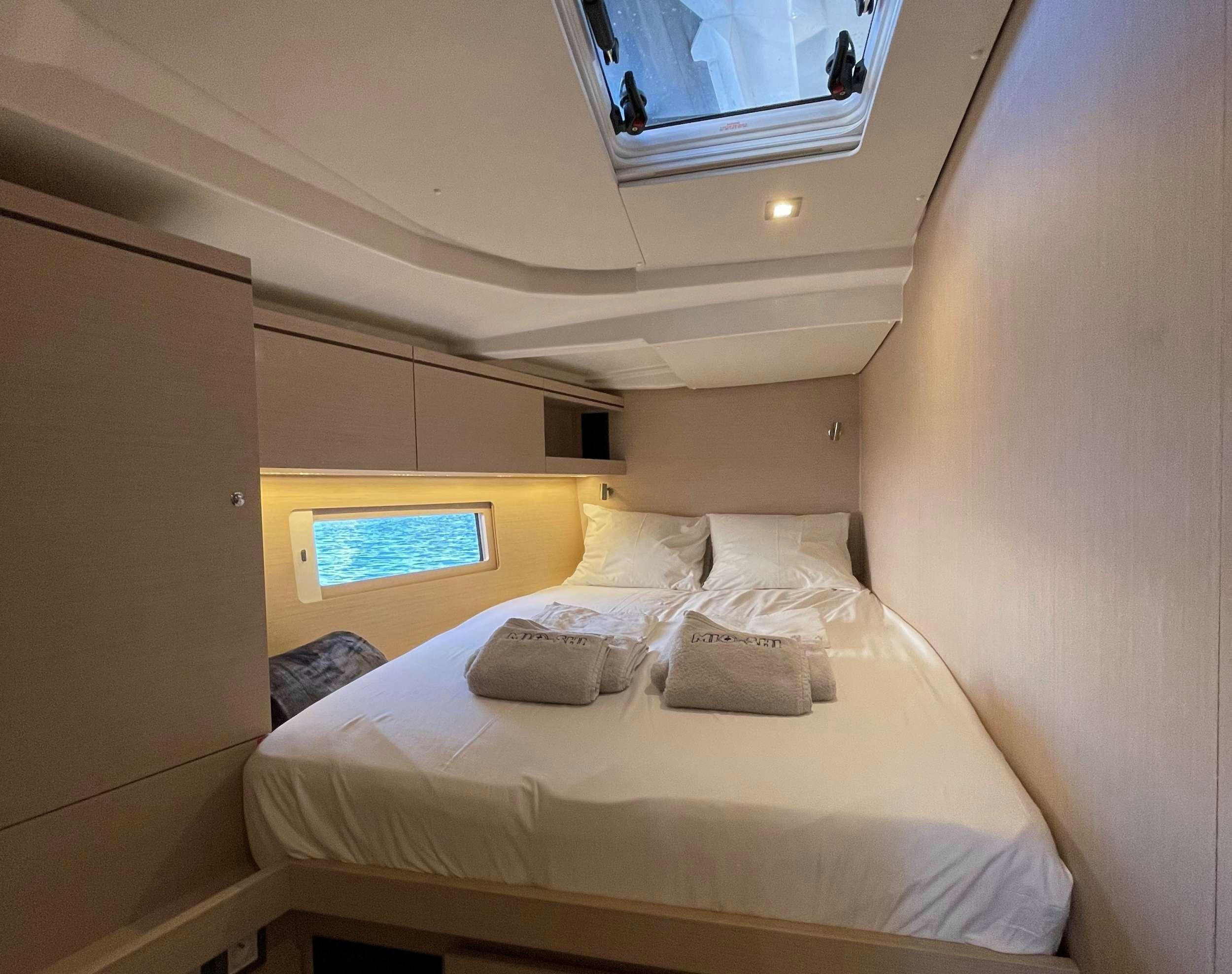 a bed with a white bed aboard MIO SHI Yacht for Charter