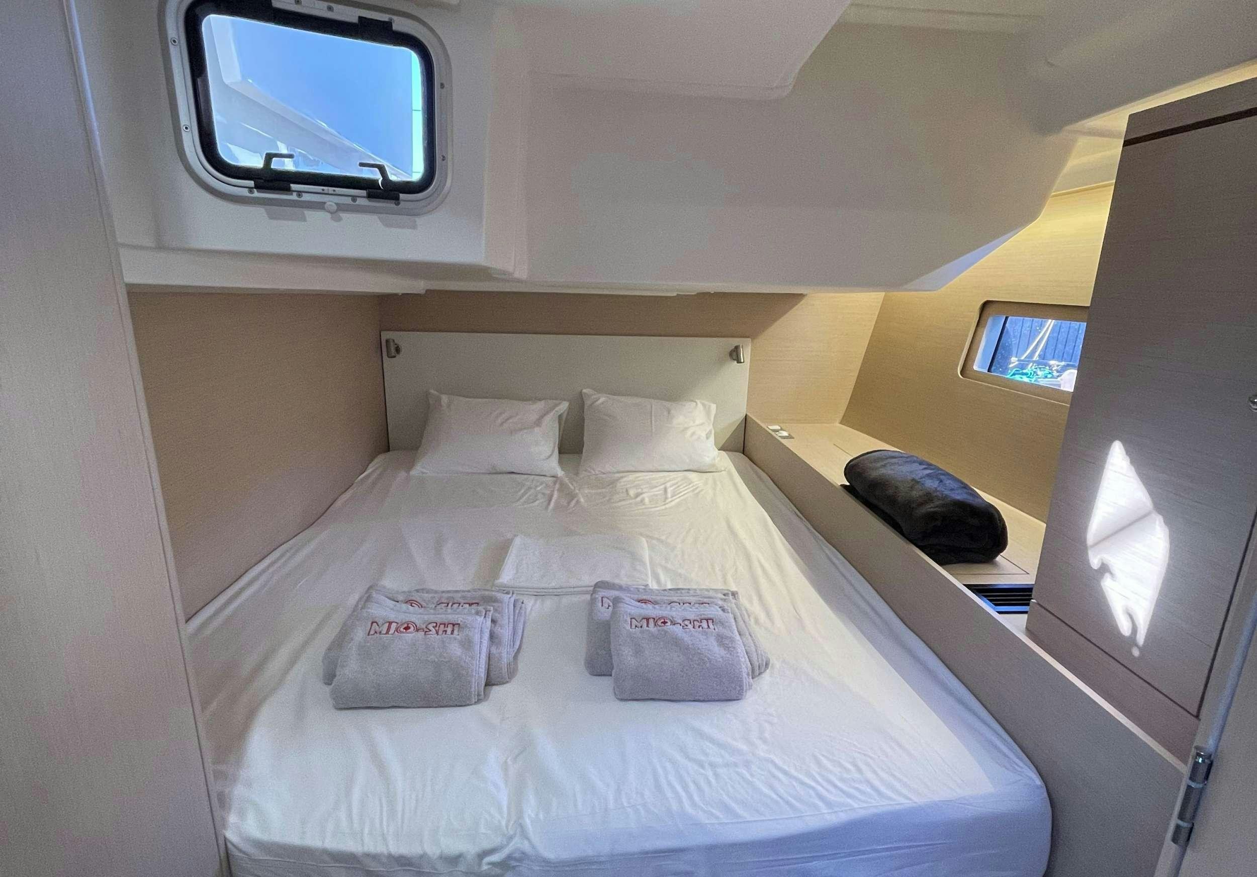 a bed with white sheets aboard MIO SHI Yacht for Charter