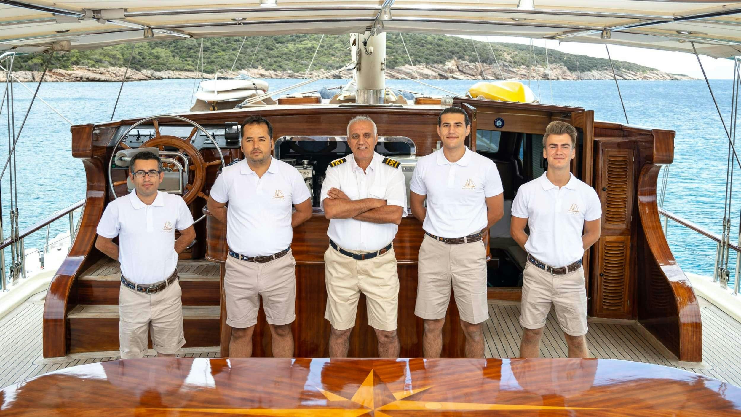 a group of men standing in front of a boat aboard ESTRELLA DE MAR Yacht for Charter