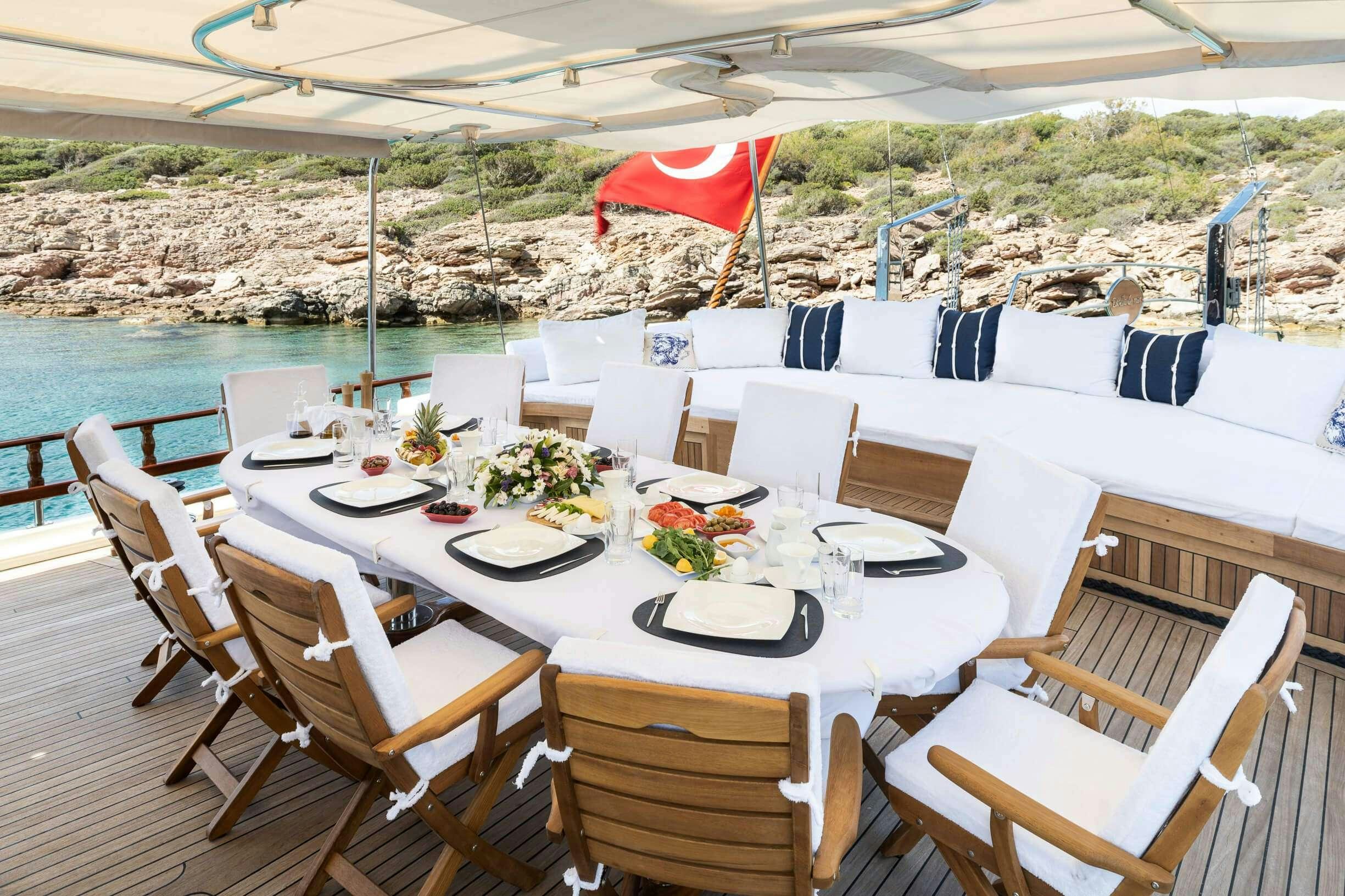 a table set for a meal on a beach aboard ESTRELLA DE MAR Yacht for Charter
