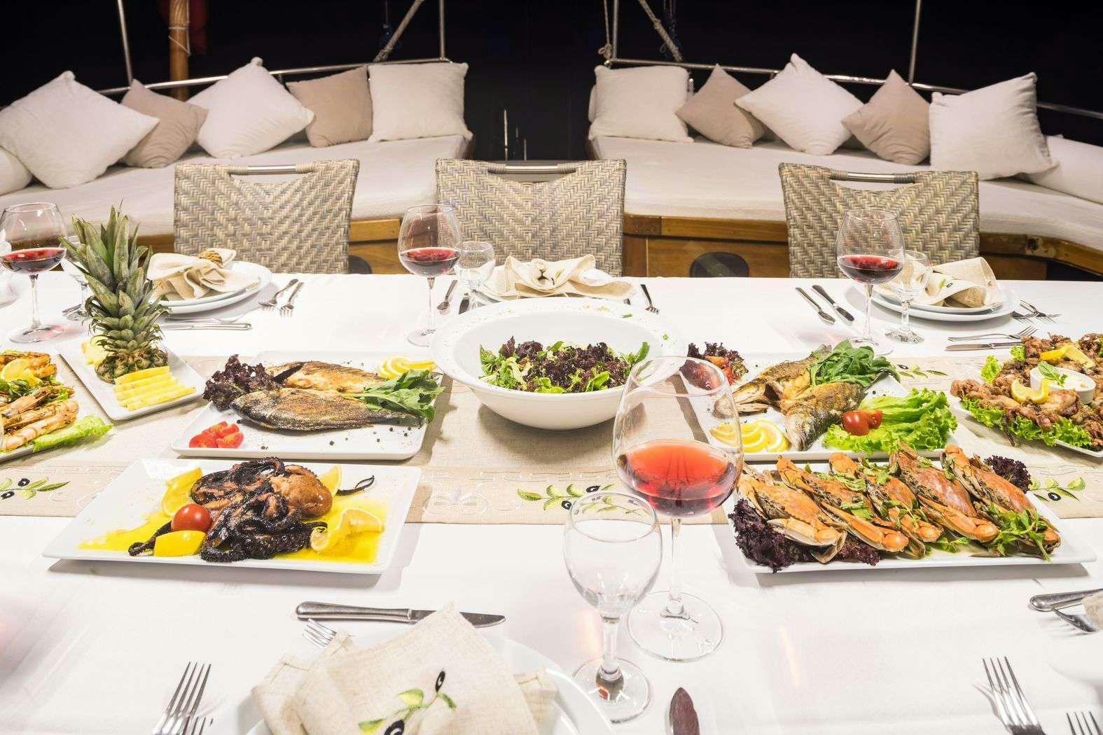 a table set with food and wine aboard S NUR TAYLAN Yacht for Charter